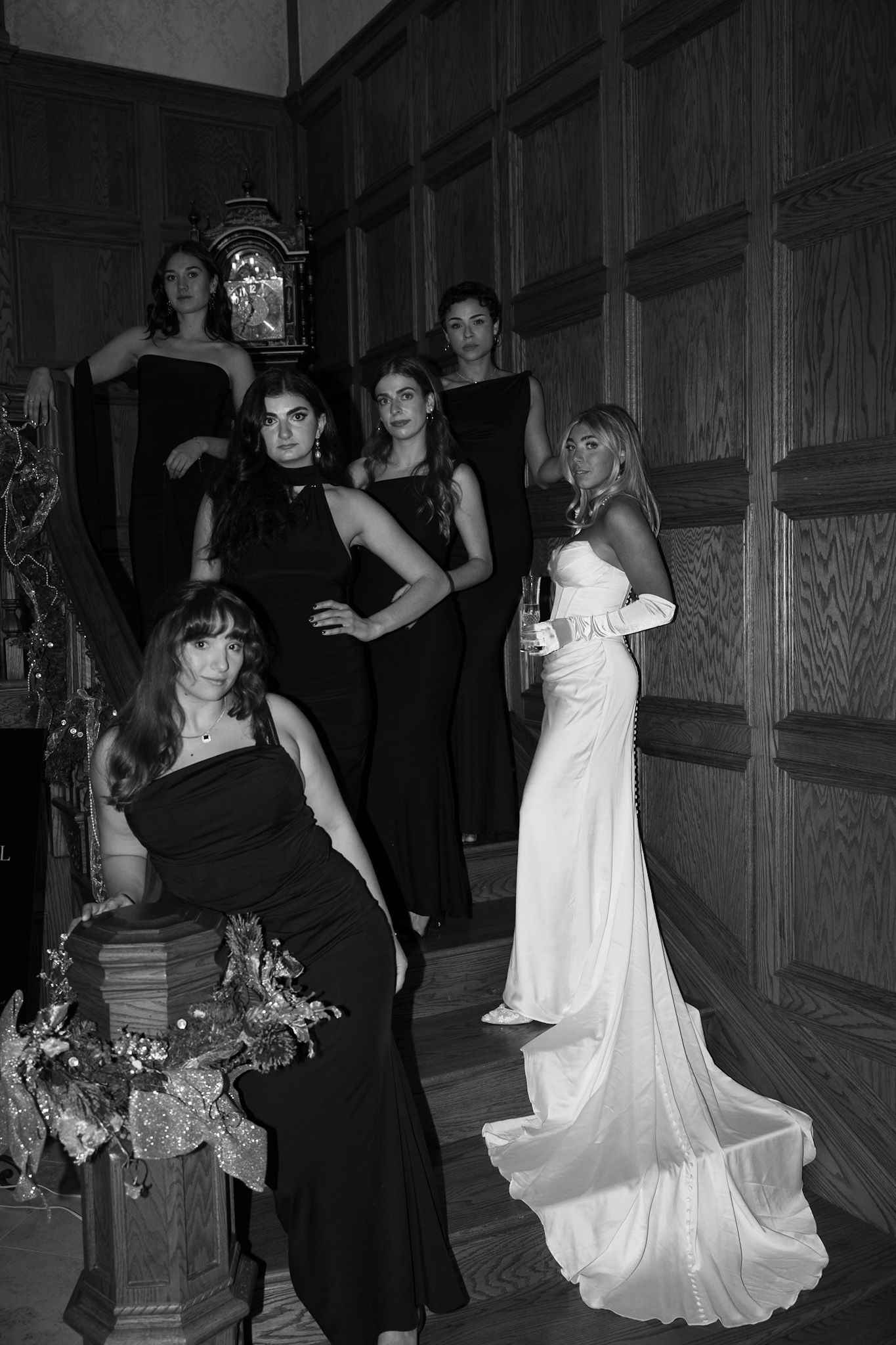 Wedding party dancing and celebrating in wood-paneled reception hall.