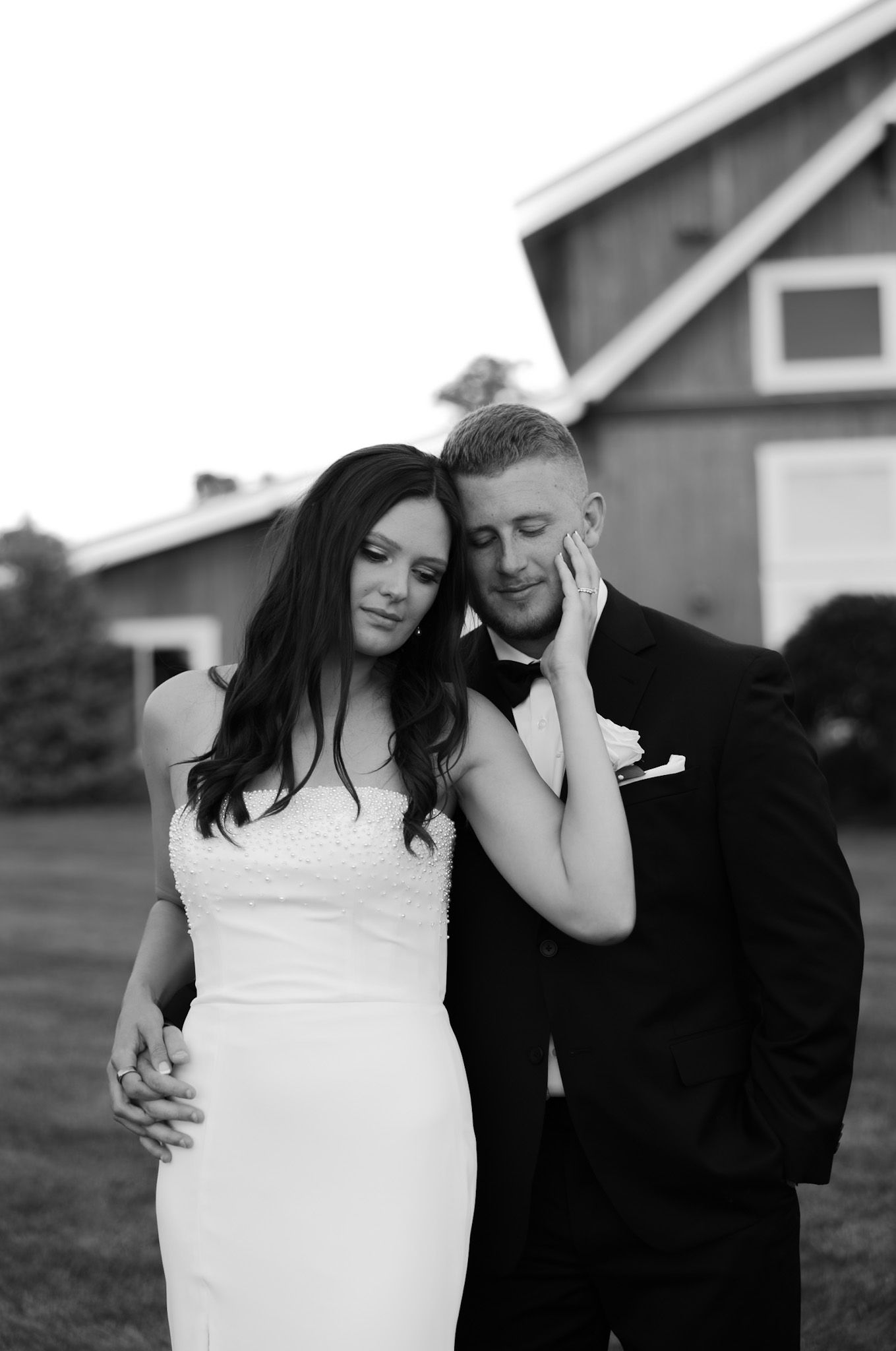 Intimate black and white wedding portraits with a rustic barn in the background.