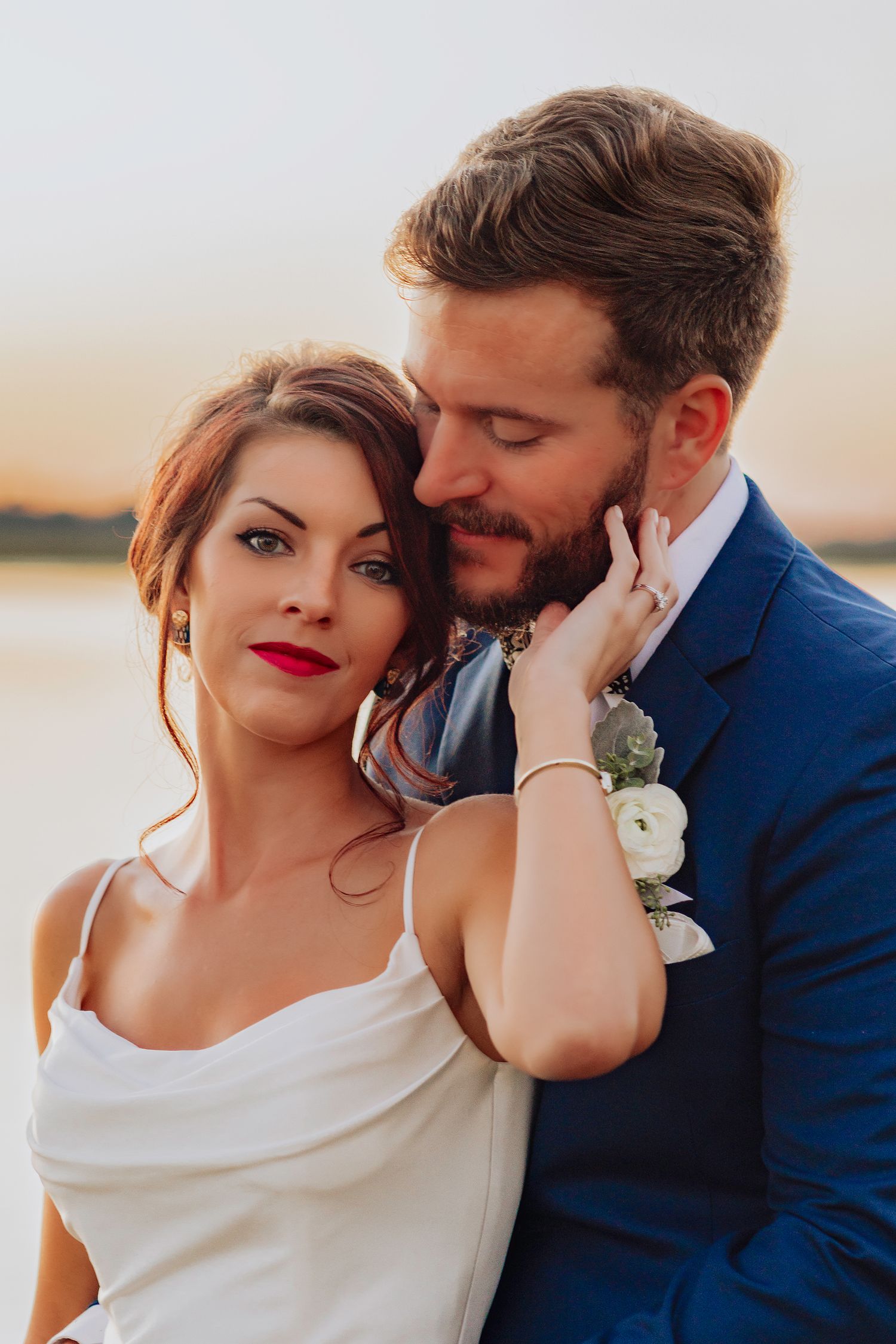 A romantic wedding couple embraces during sunset in a series of intimate portrait photographs.