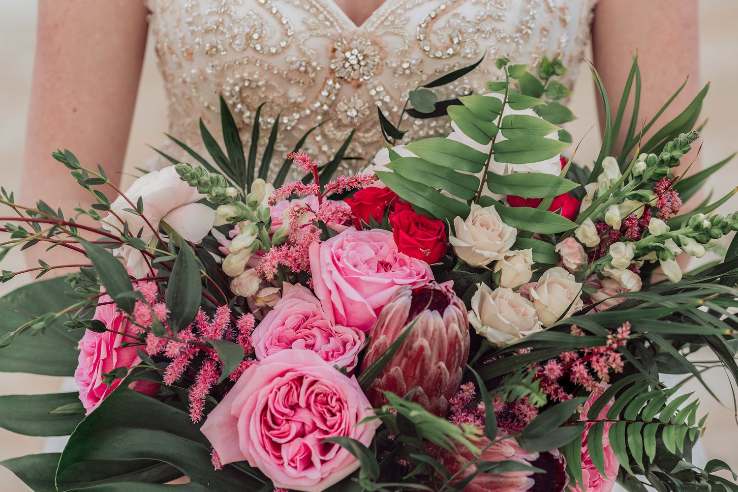A beautiful floral arrangement featuring pink roses, white lilies, and green leaves in a decorative display in St. Augustine Florida