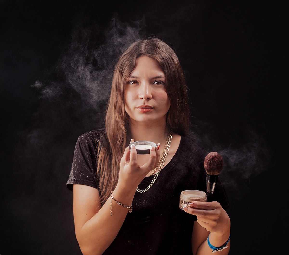 A person holding a vaping device and lollipop poses against a dark background with smoke effects.