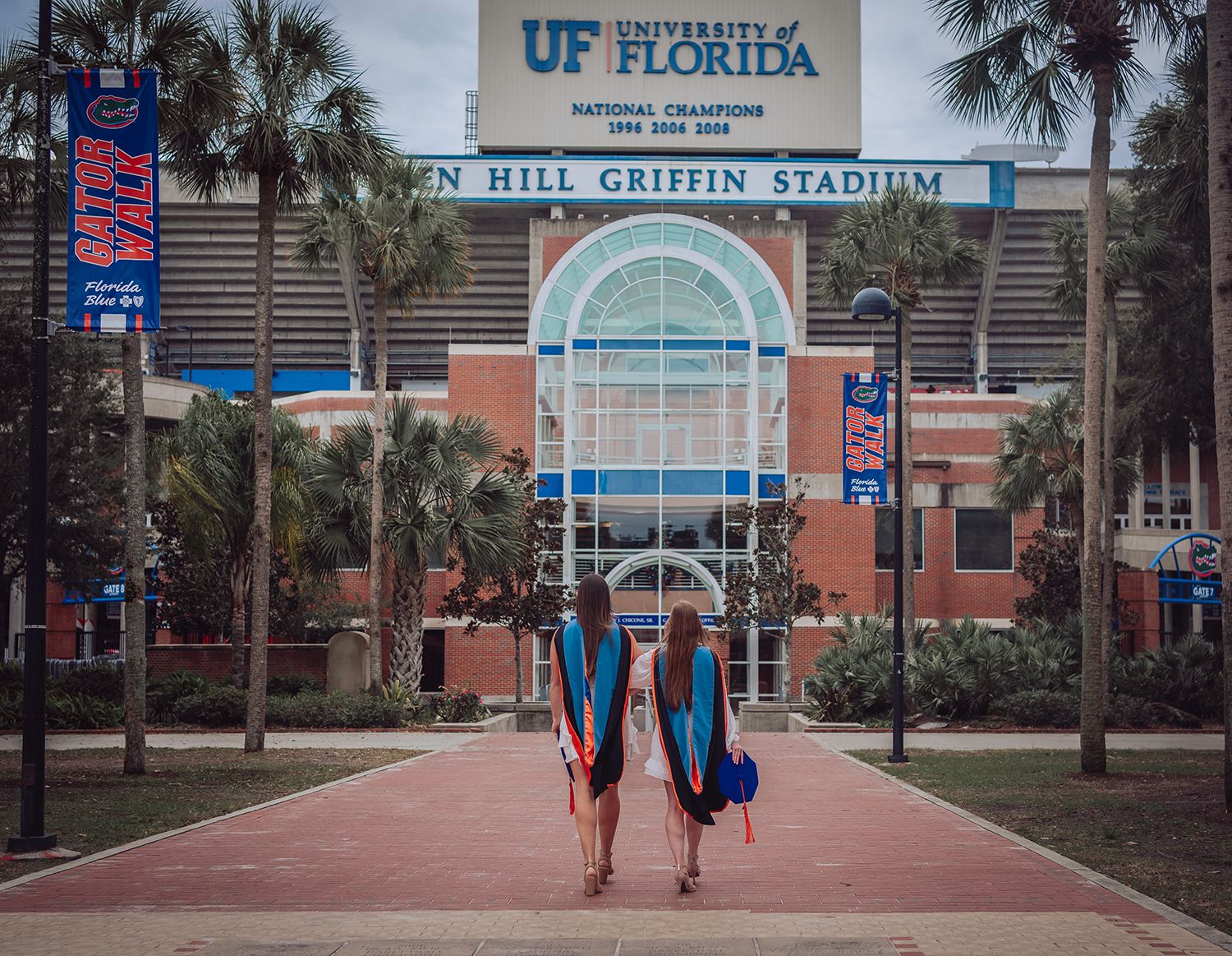 Palm trees line the entrance walkway to Ben Hill Griffin Stadium at the University of Florida campus for graduation photos in Gainesville Fl