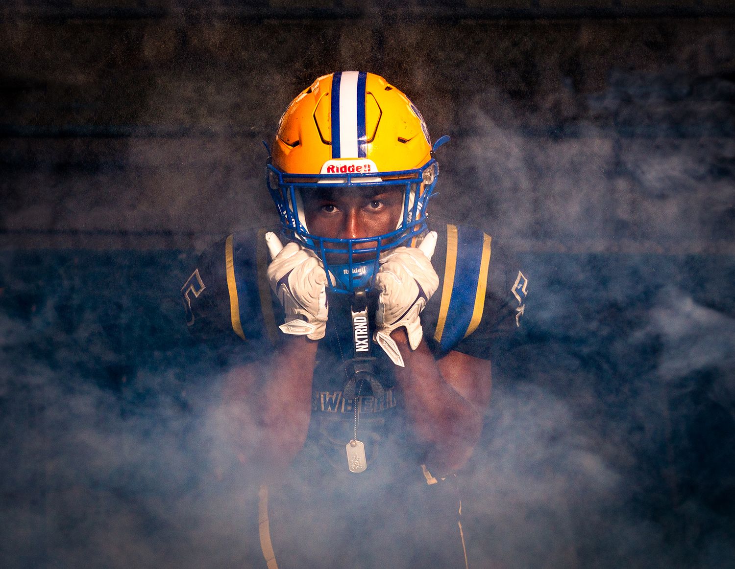 Football player emerges through dramatic smoke and lighting effects at a stadium entrance for Newberry Panthers Football in Newberry, Fl