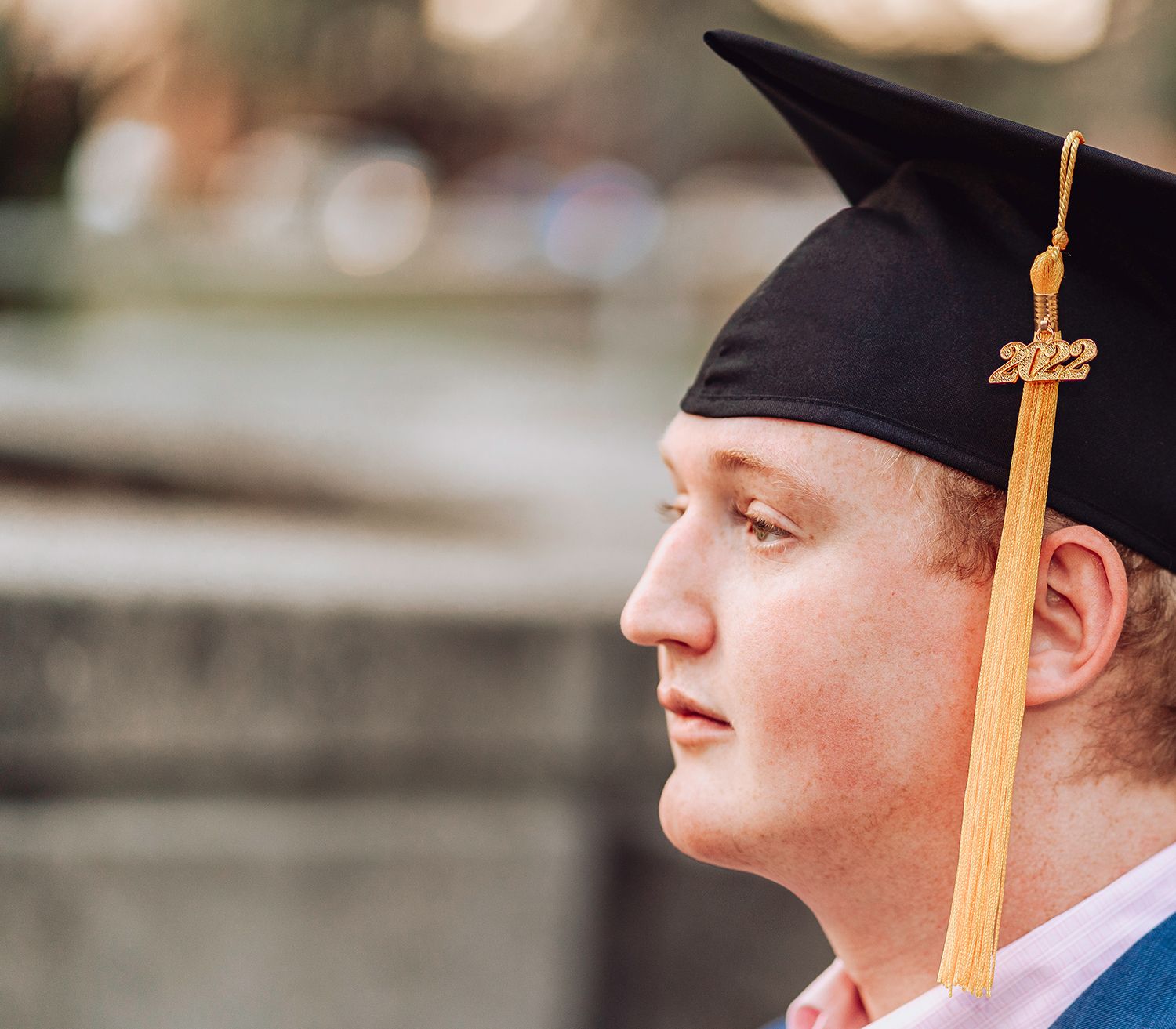 A graduate in black cap with gold tassel looking to the side at the University of Florida in Gainesville, Florida.
