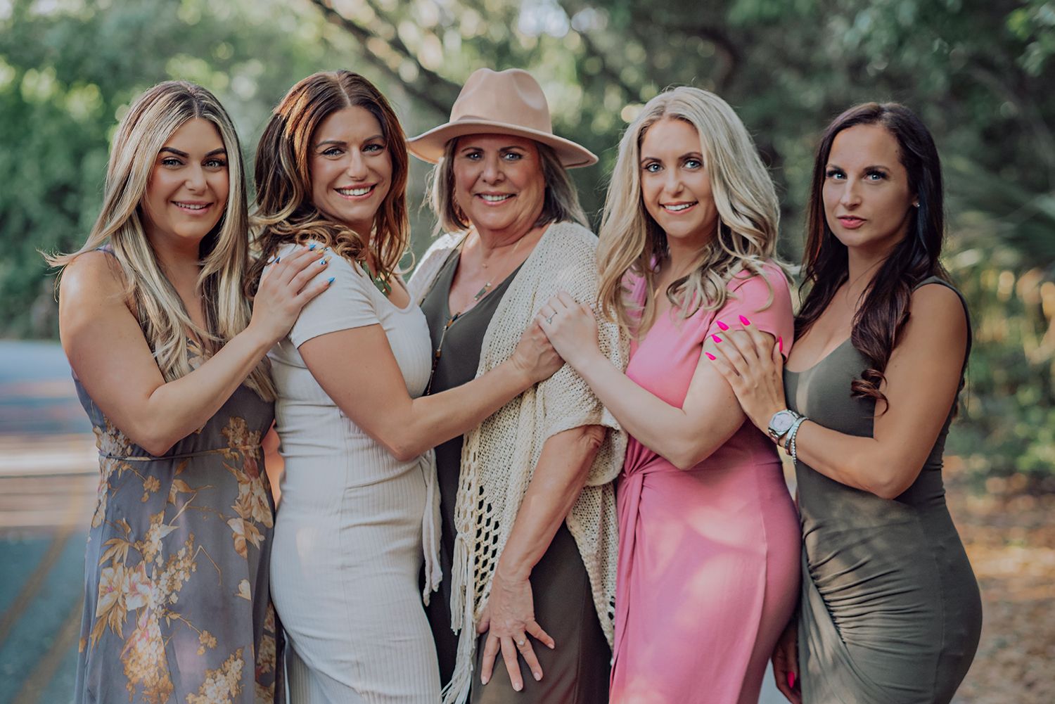 Adult family photos wearing casual summer attire laughing and embracing outdoors in natural lighting in Jacksonville Florida