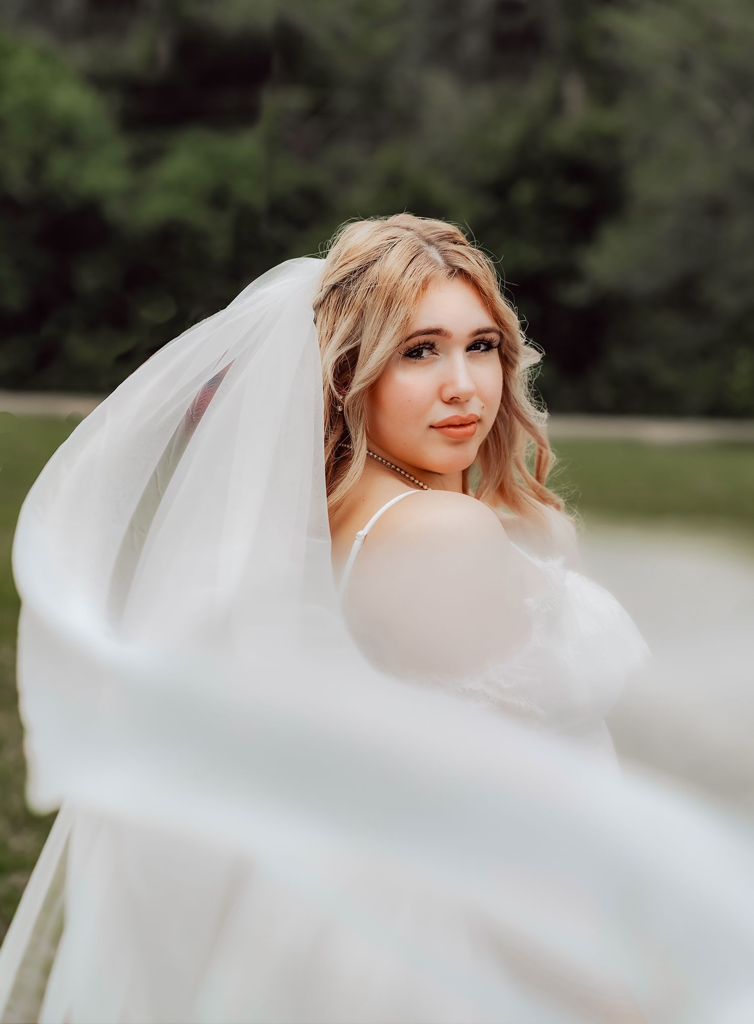 A bride in a white wedding dress twirls gracefully in an outdoor setting, creating flowing movement with her gown for wedding photographer