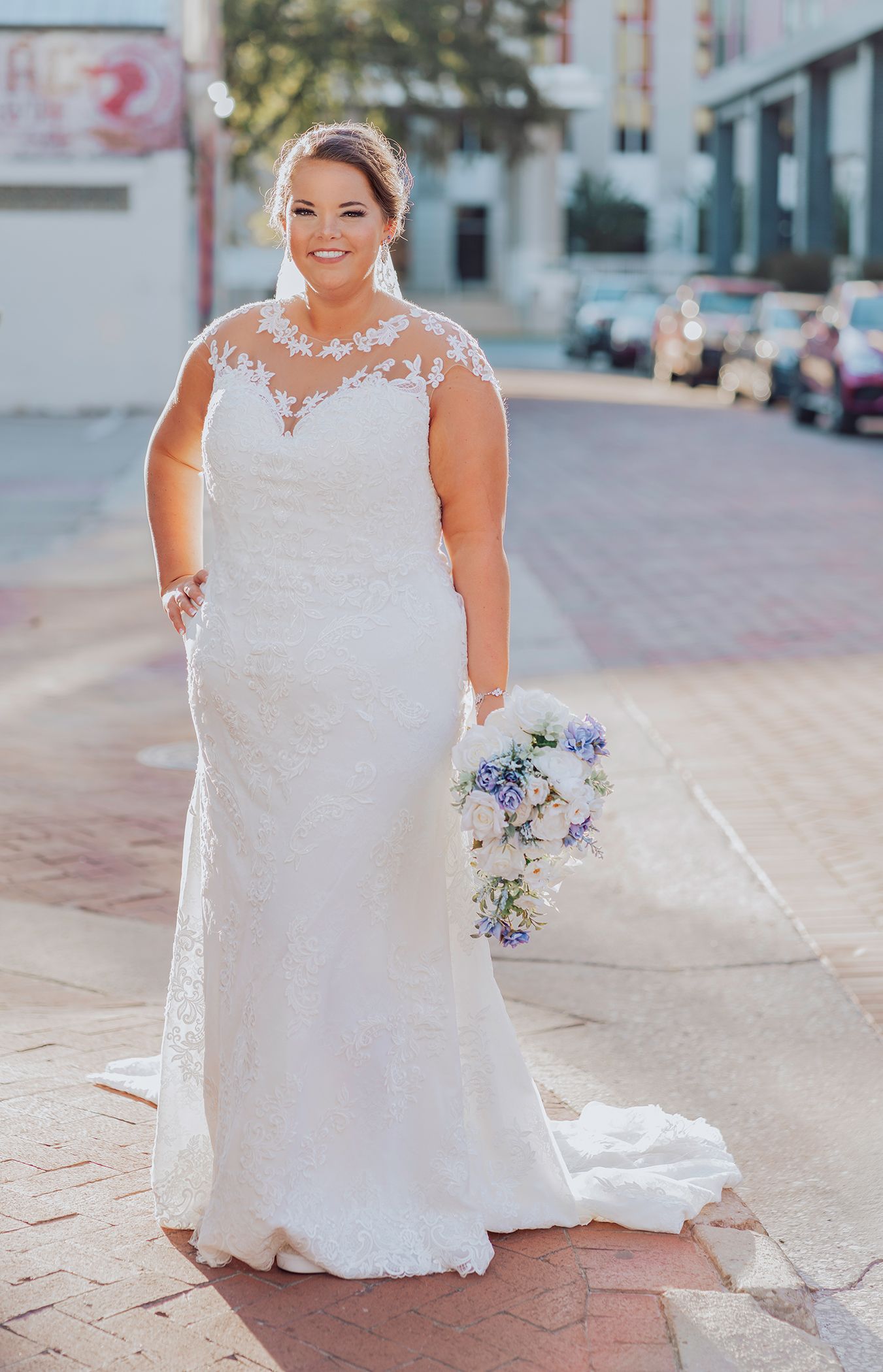 A bride in a white lace wedding dress poses with her bouquet on brick pavement in a series of photos.