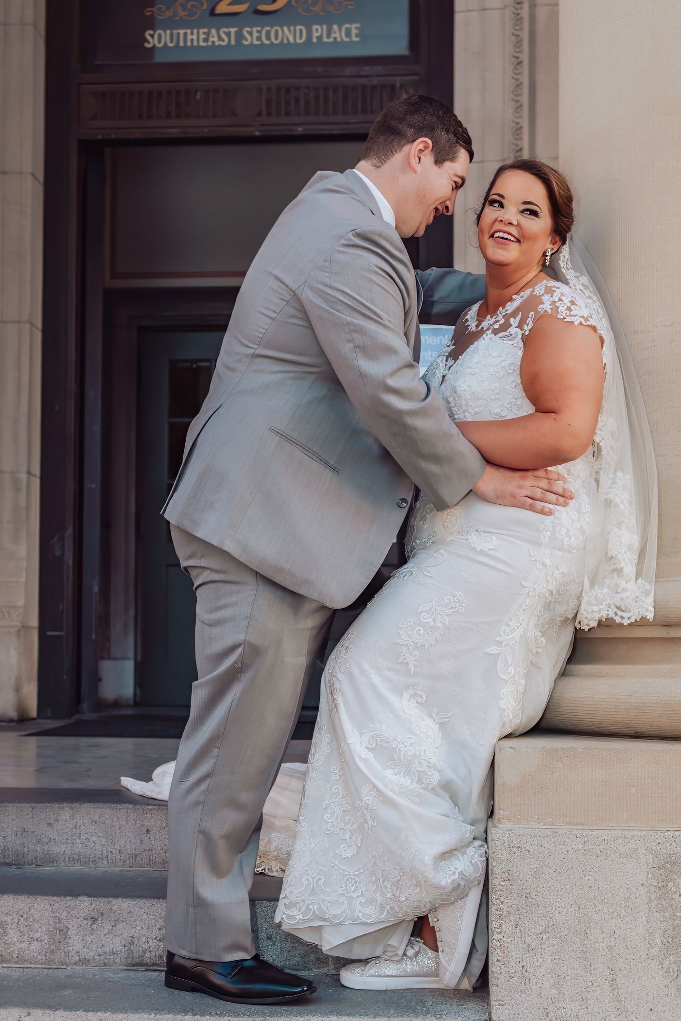 Bride and groom posed against stone columns  of the hippodrome in Gainesville FL for wedding photography.
