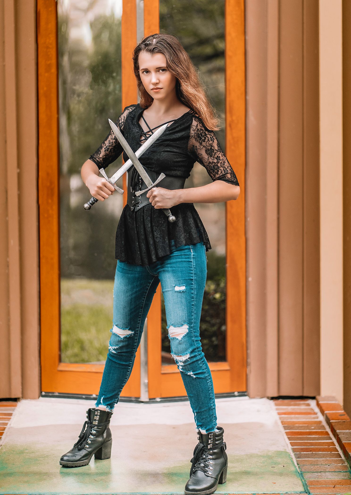 High school senior wearing ripped blue jeans and black boots for graduation photos in Gainesville, Florida