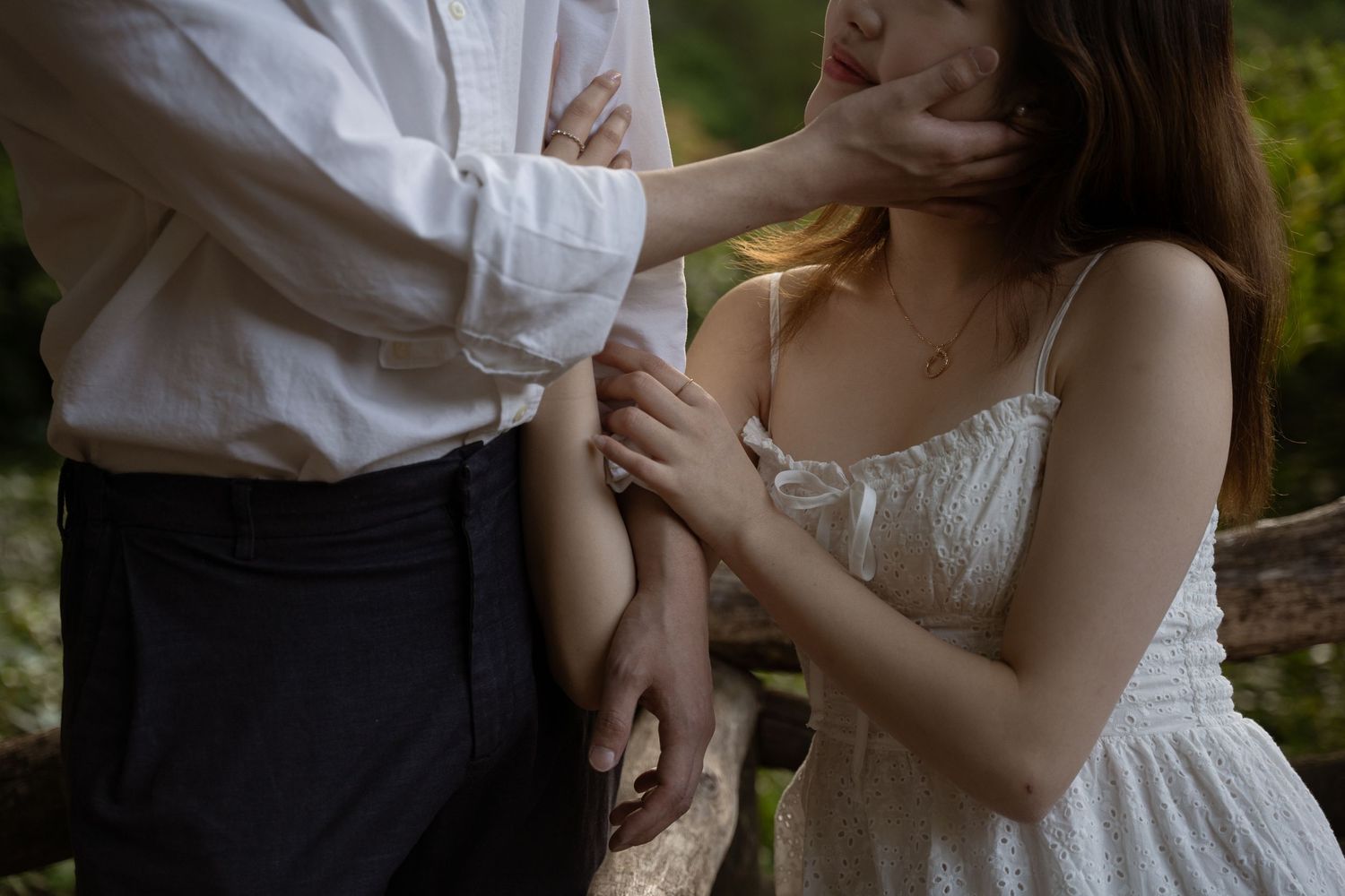 Romantic couple sharing tender moments in a garden setting wearing formal attire.