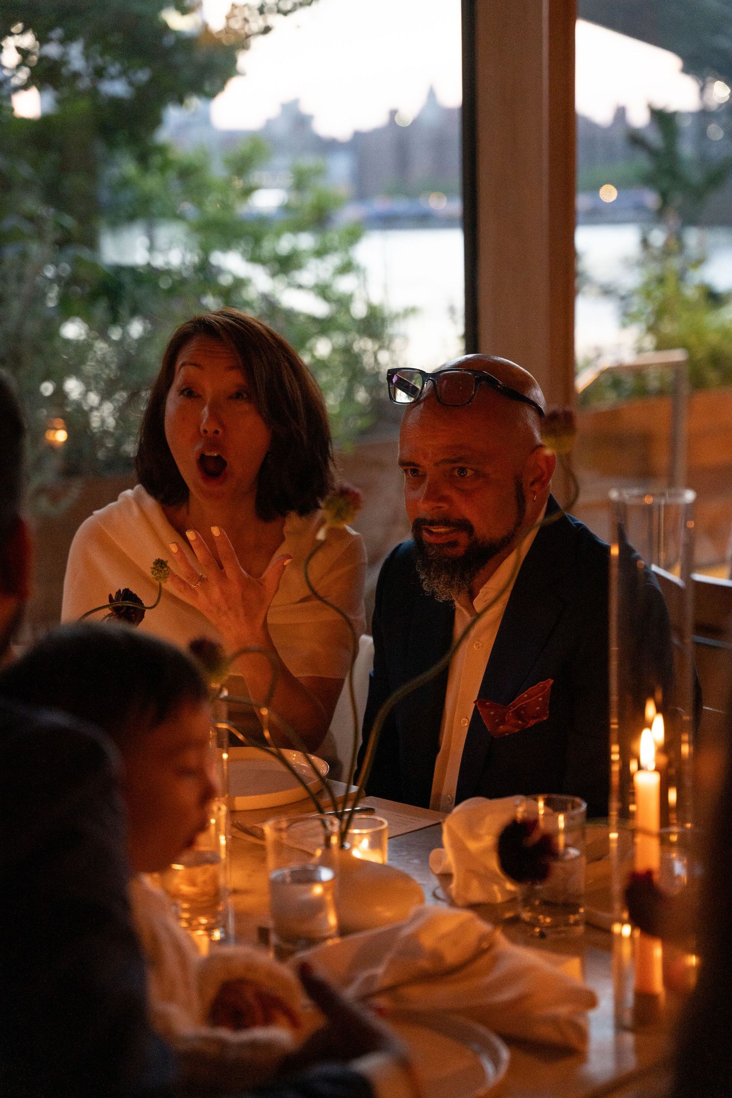 Guests dining at a candlelit table during an evening reception.