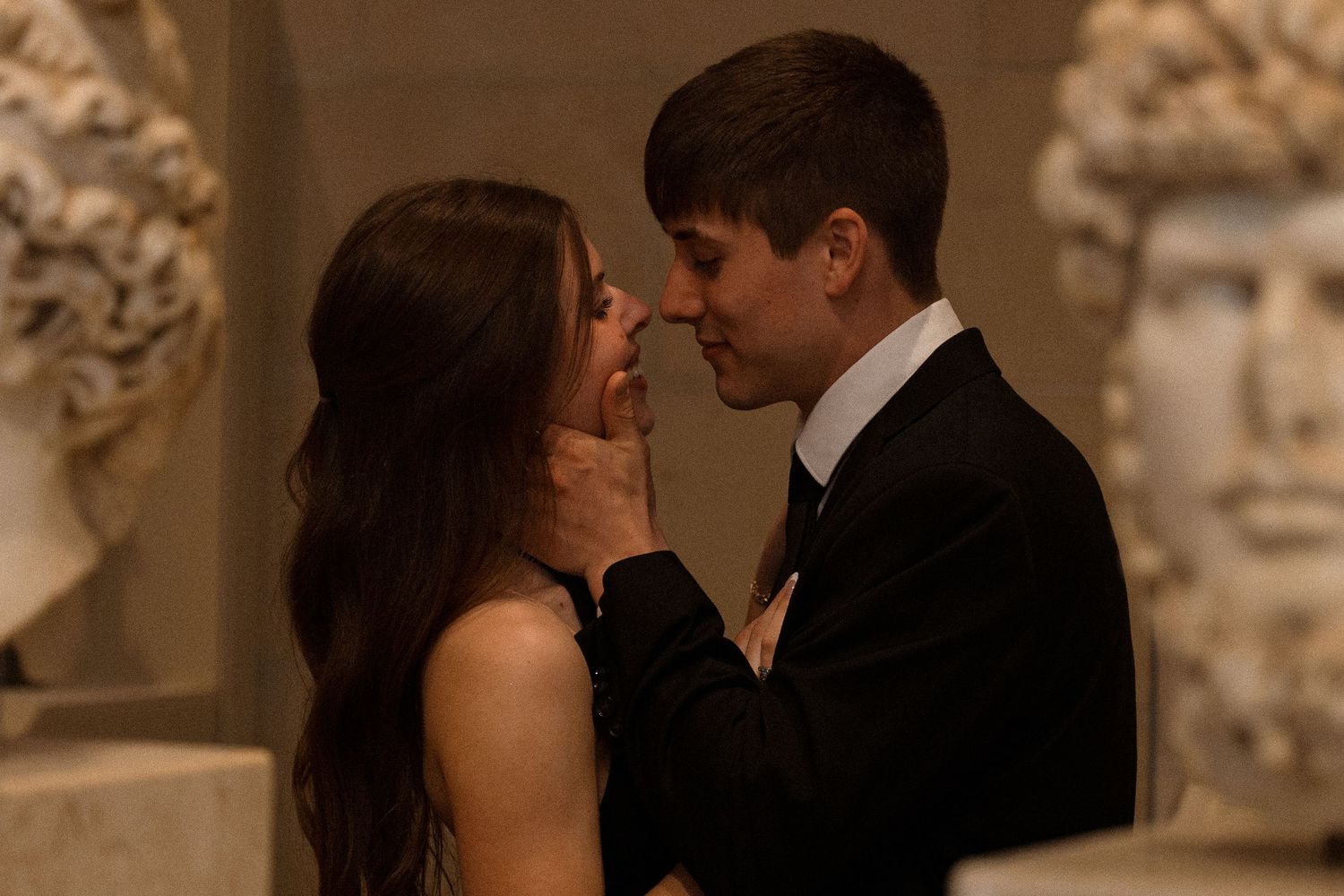 An intimate dance moment captured in sepia tones within a museum setting.