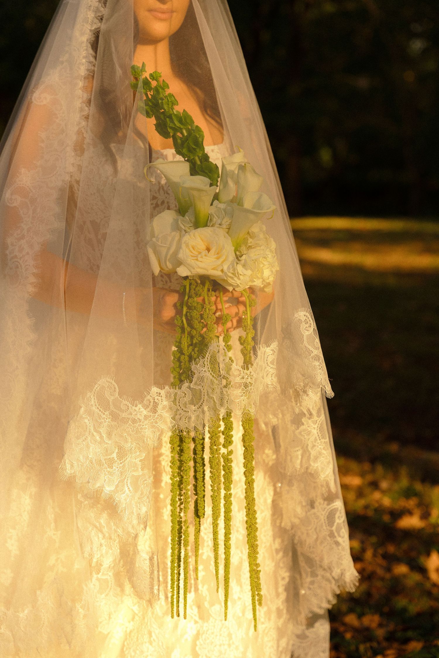 Delicate lace veil catches sunlight creating ethereal golden glow in autumn setting.