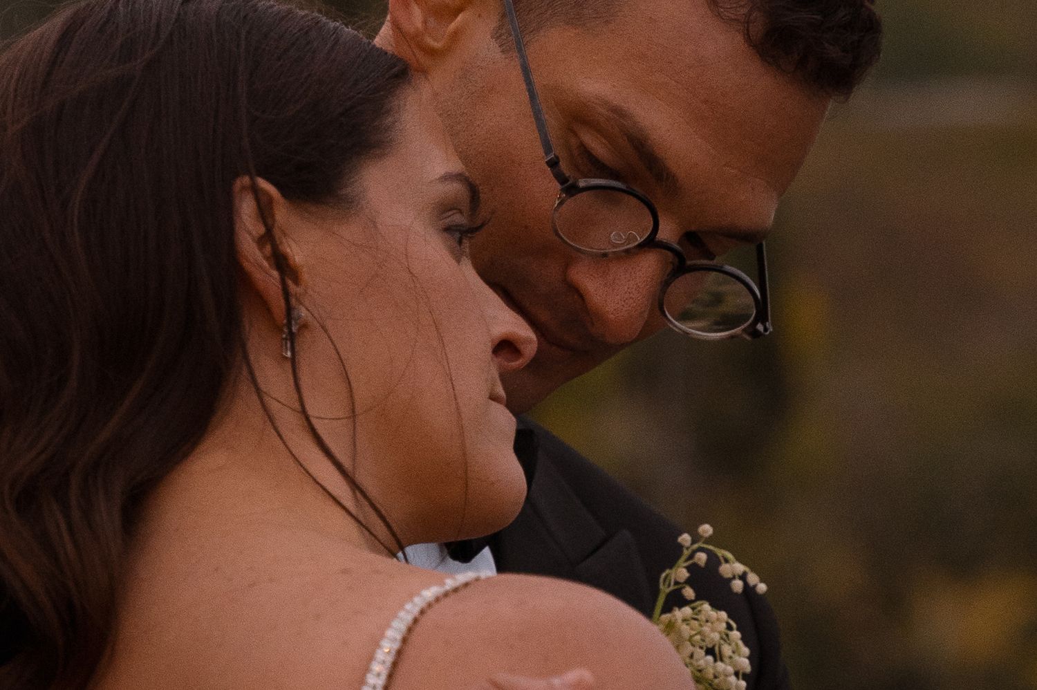 Intimate close-up portrait of couple sharing tender moment outdoors.