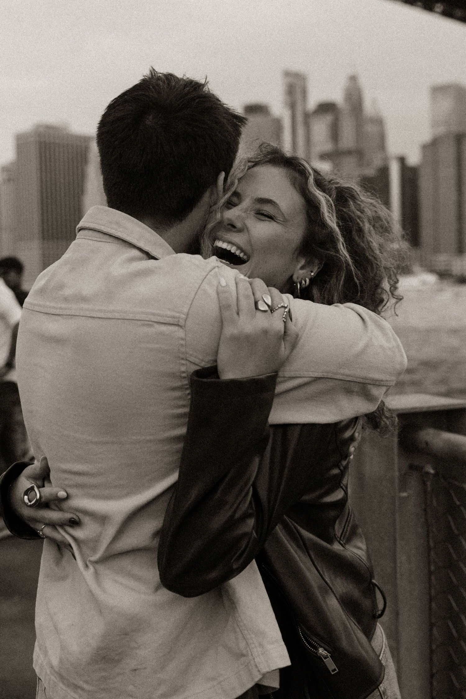 A romantic black and white photo sequence shows a couple embracing and kissing with a city skyline in the background.