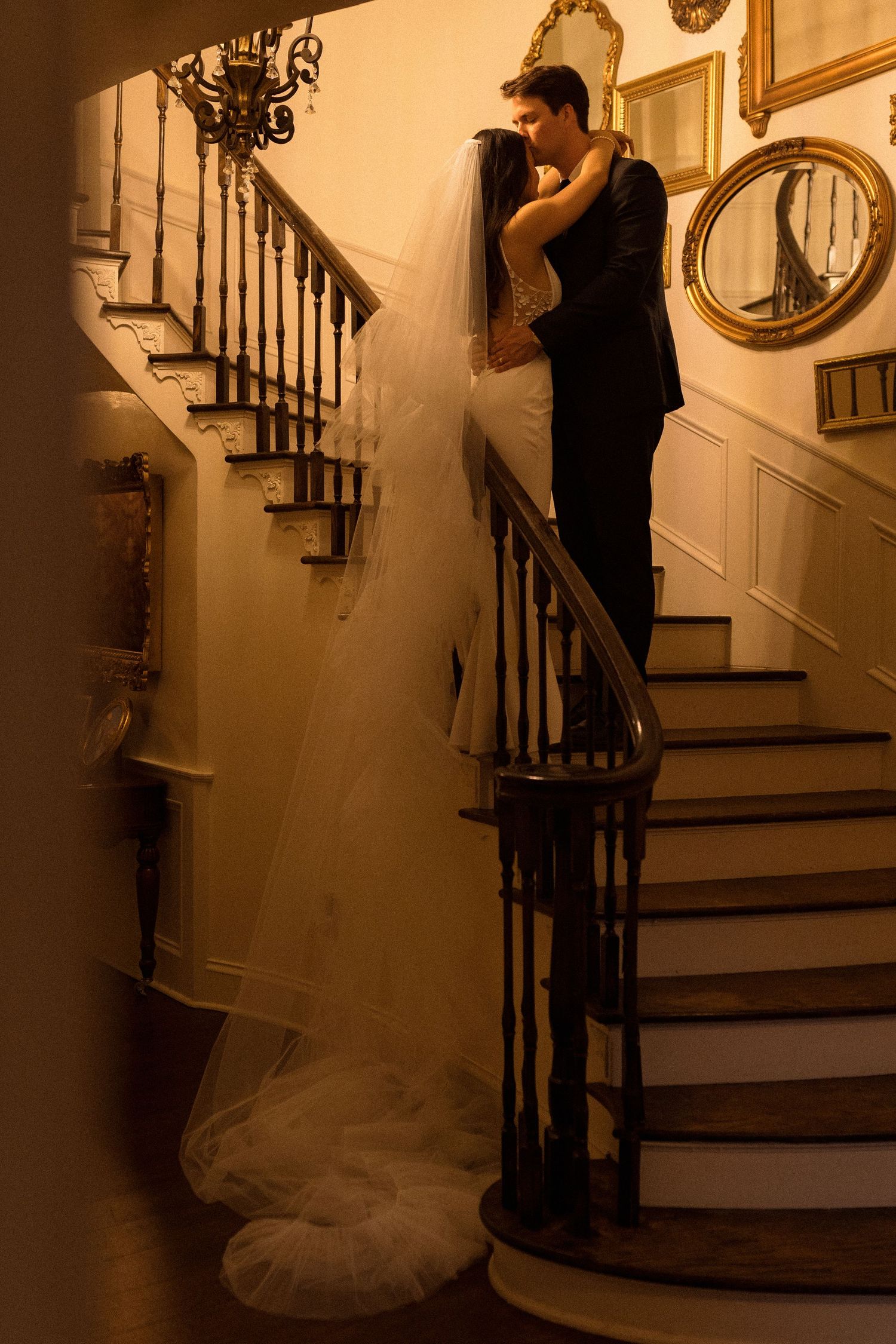 A romantic staircase scene with dramatic lighting and flowing wedding dress details.