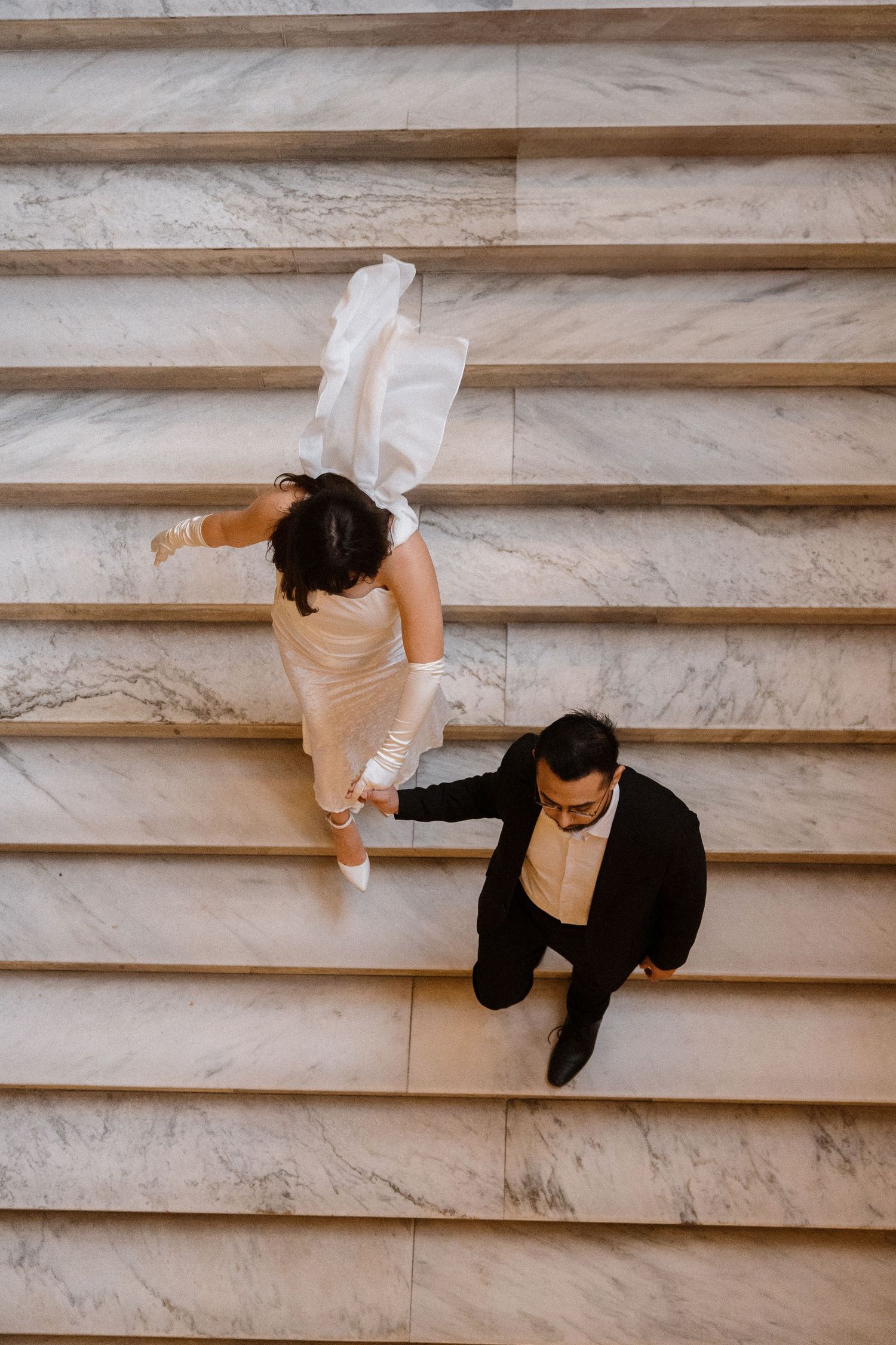 Two dancers perform on marble steps in contrasting black and white outfits.