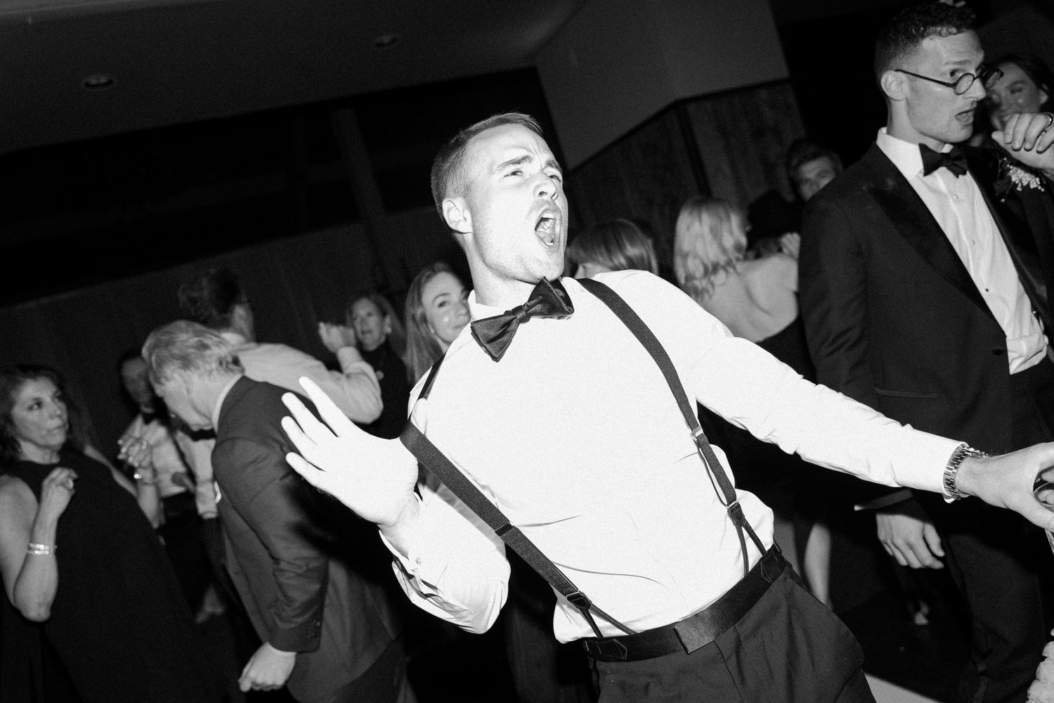 Wedding reception dance floor filled with energetic guests.