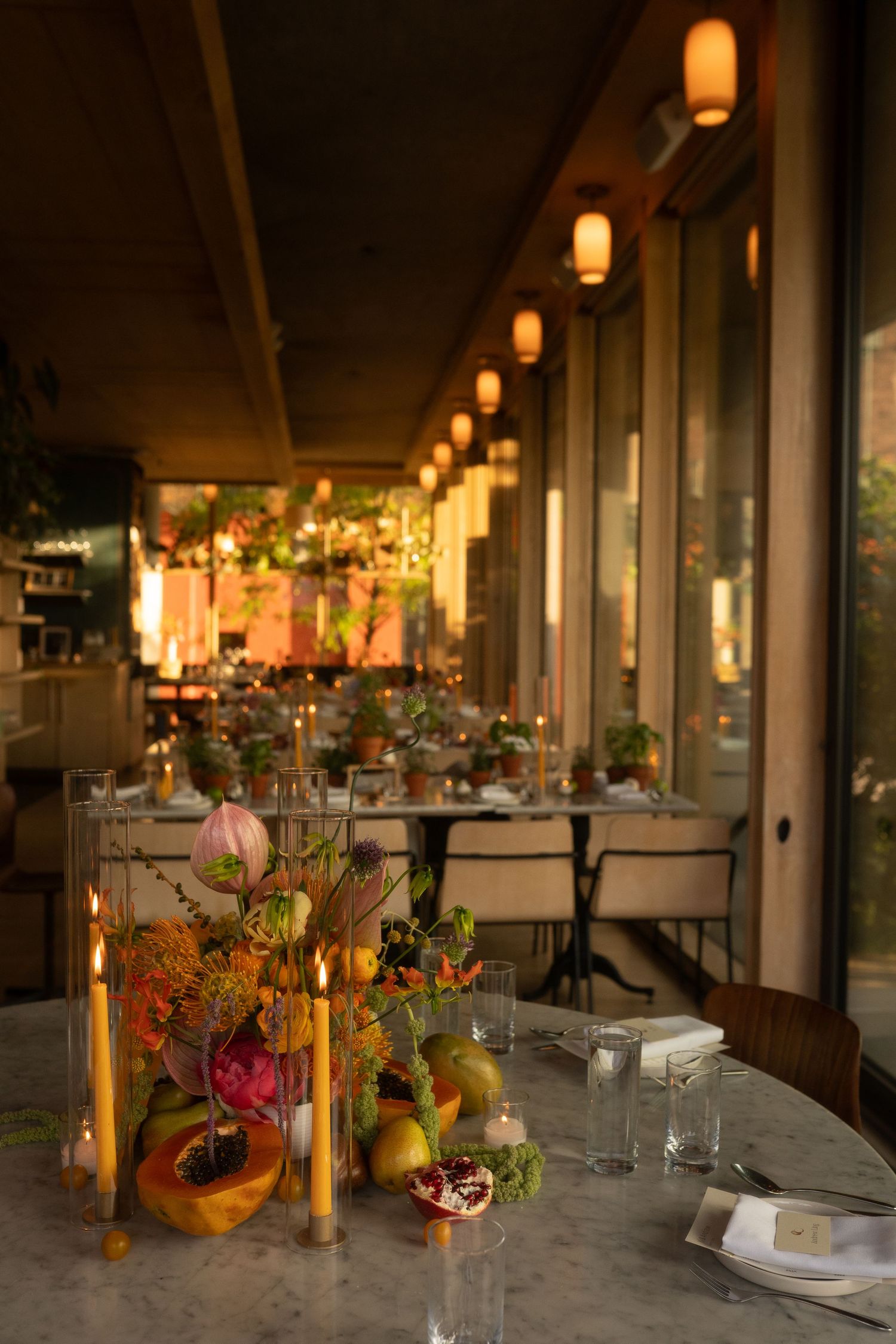 An elegantly set wedding reception table with floral centerpieces and glowing lanterns.