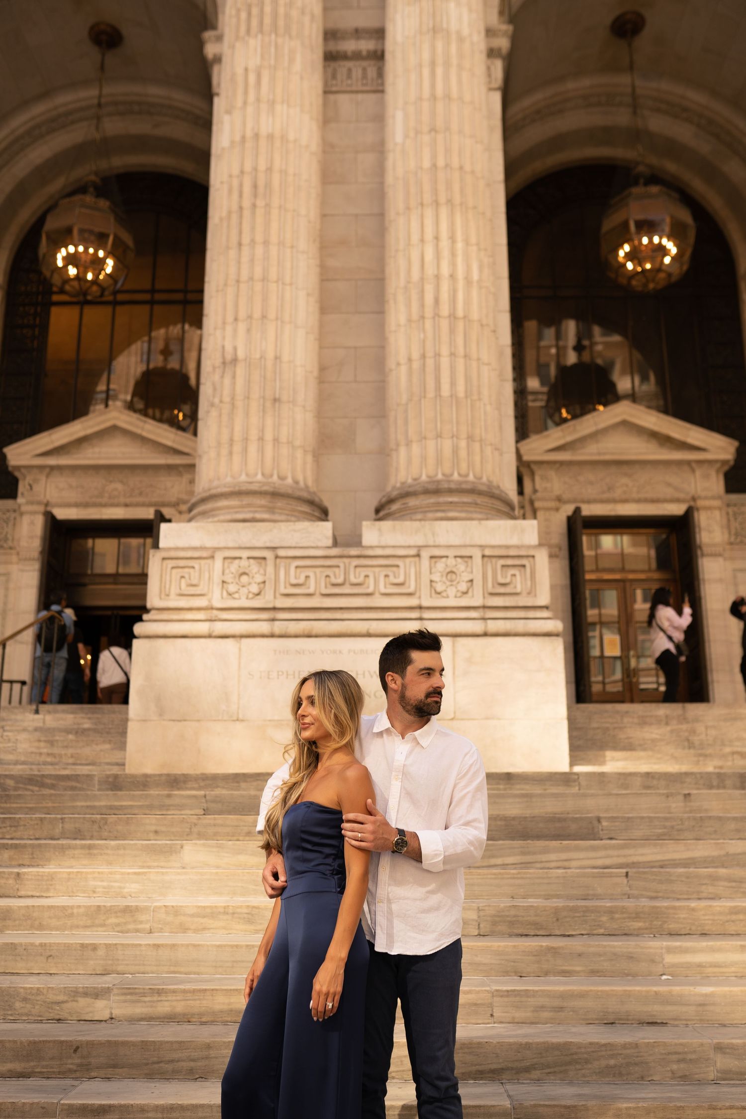 A couple sharing an intimate moment on grand marble steps of a neoclassical building.