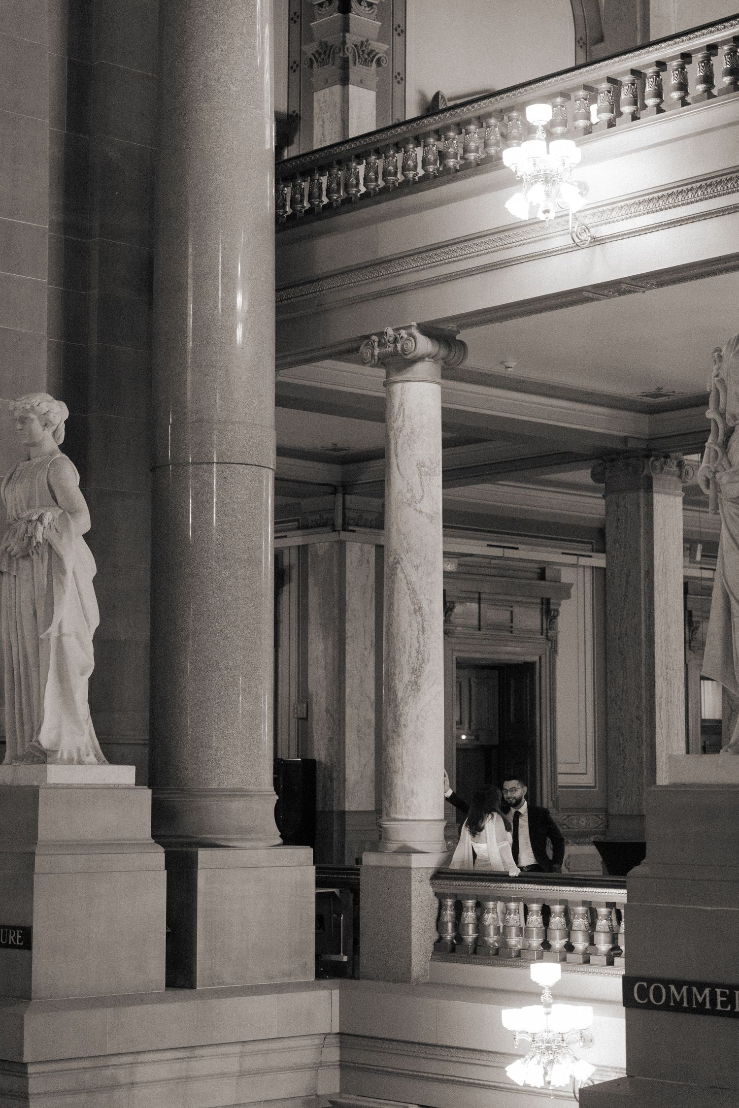 Grand interior hall with classical columns, statues and ornate architectural details.
