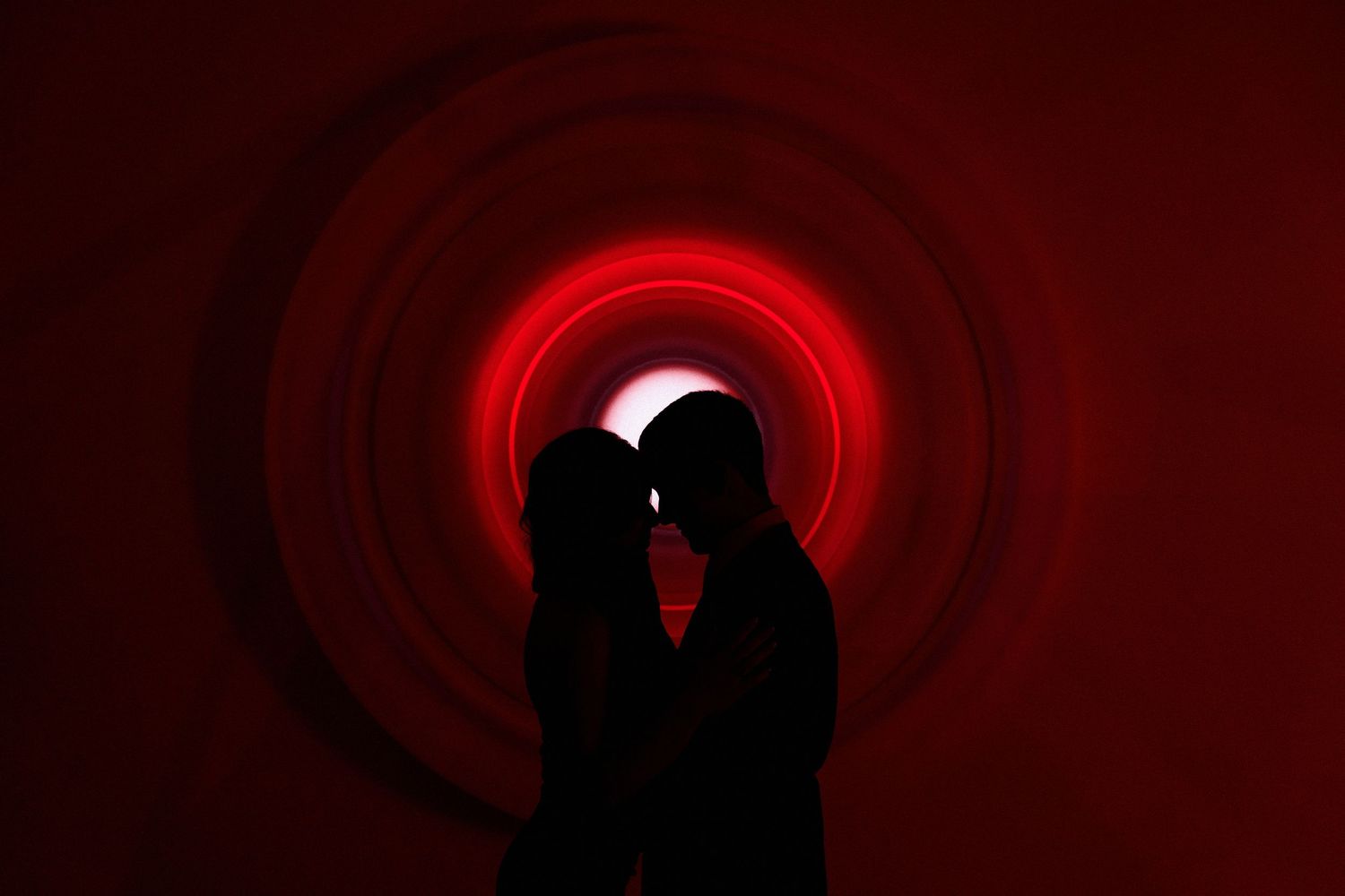 Dramatic silhouettes against red circular lighting effects.