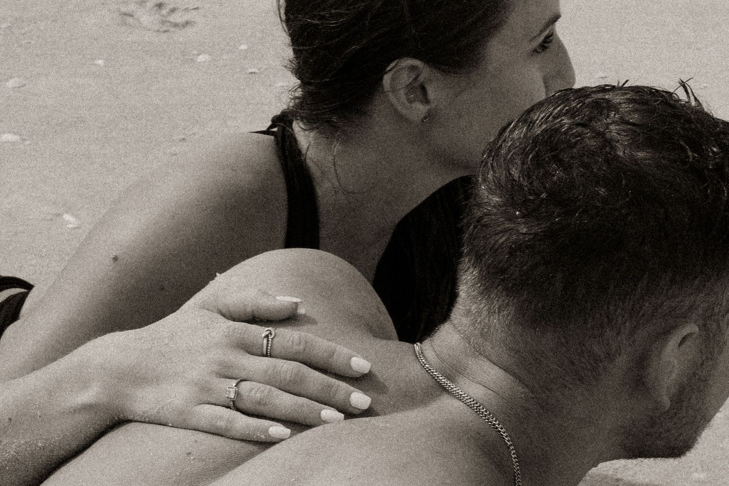 Intimate black and white portraits showing tender moments between a couple on the beach.