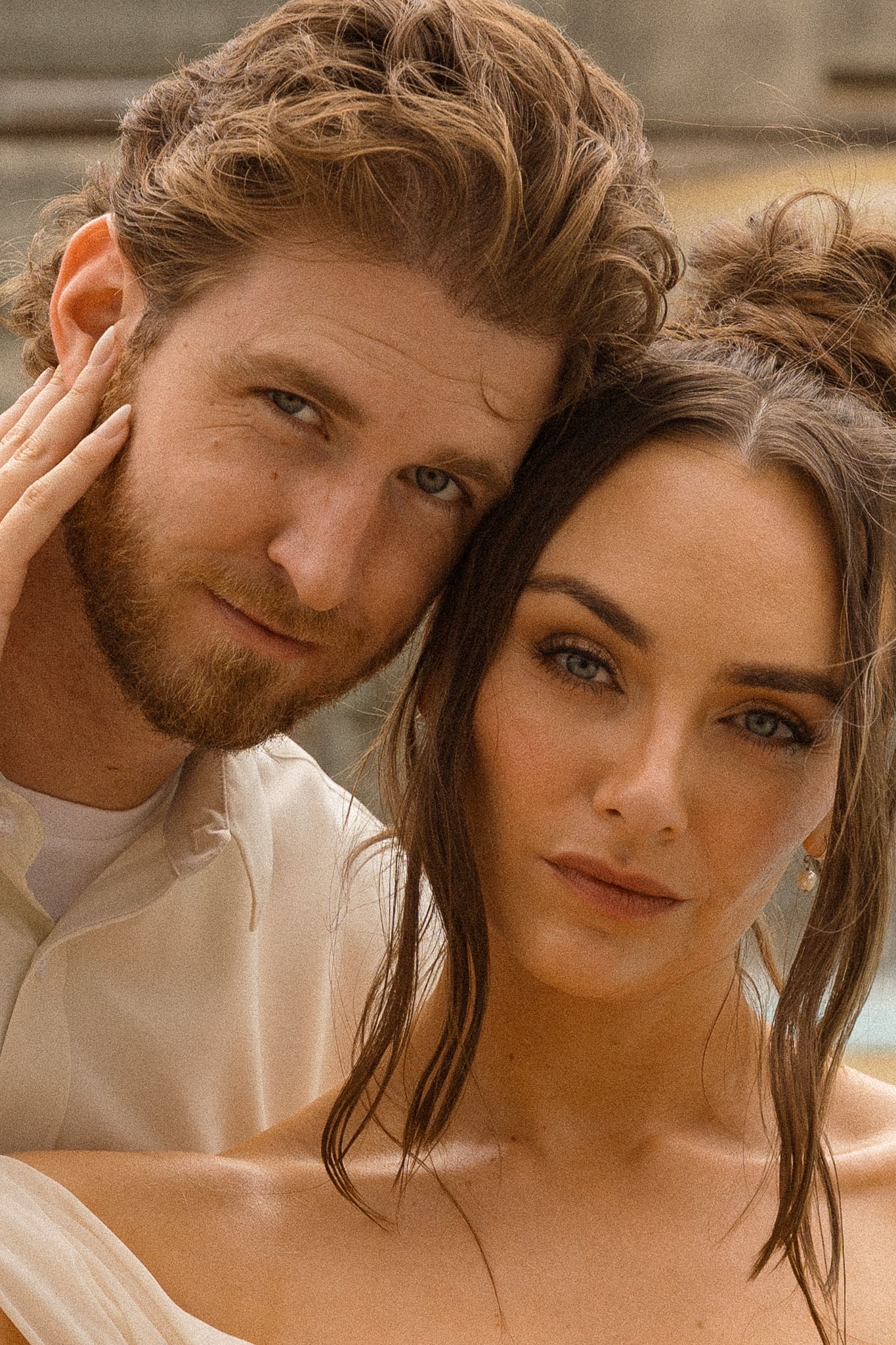 Close-up portrait of a couple in warm sunlight.
