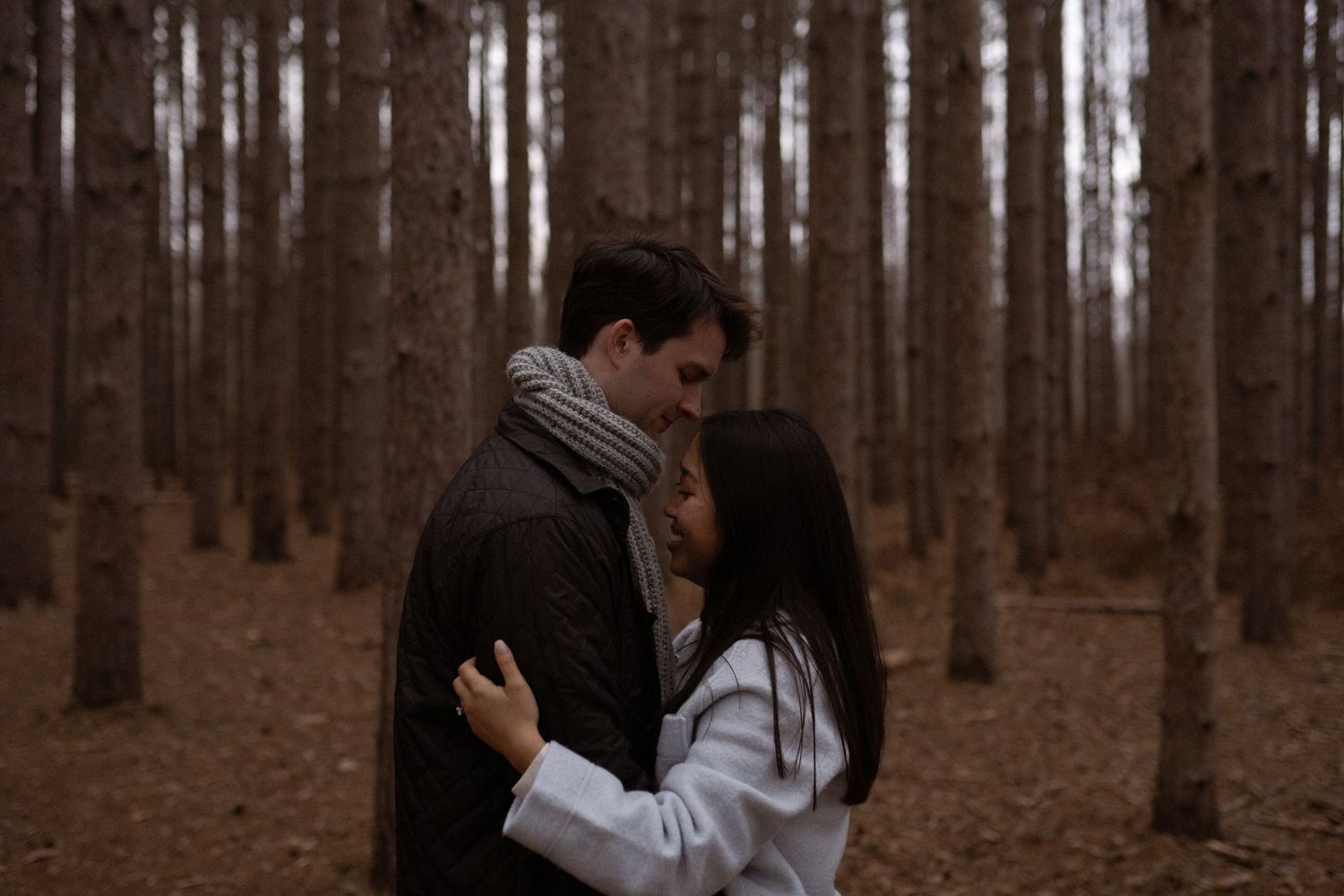 A romantic sequence of silhouettes among tall trees in a moody forest setting.