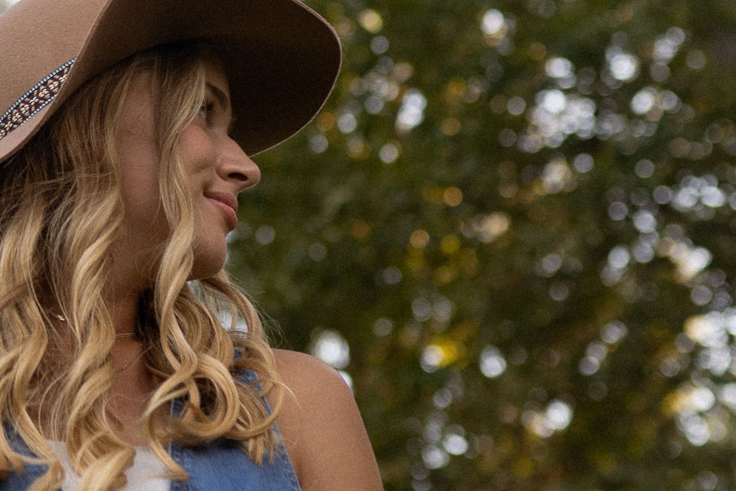 Stylish outdoor portrait session featuring a wide-brimmed hat in natural lighting.