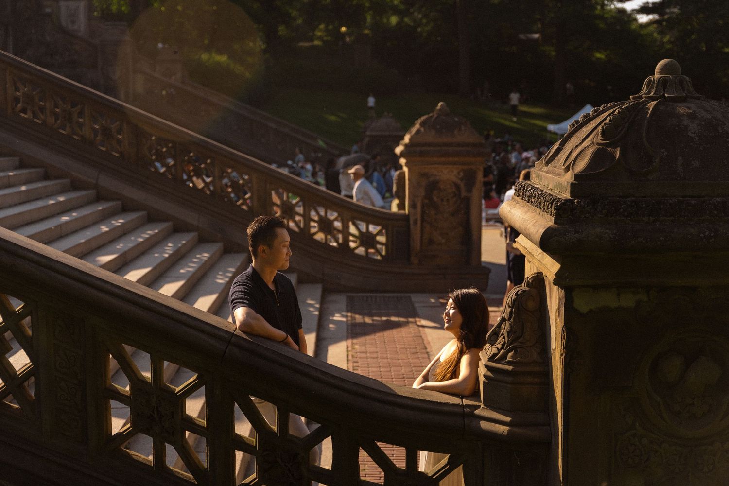Figures pose dramatically on stone steps at sunset creating long shadows.