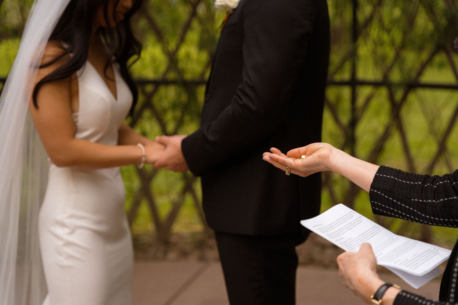 Wedding ceremony participants exchanging papers during an outdoor service.