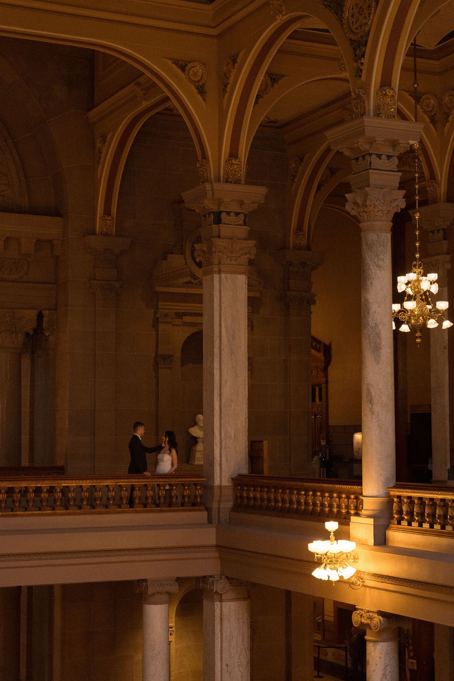 An ornate historic ballroom interior with grand columns and crystal chandeliers.