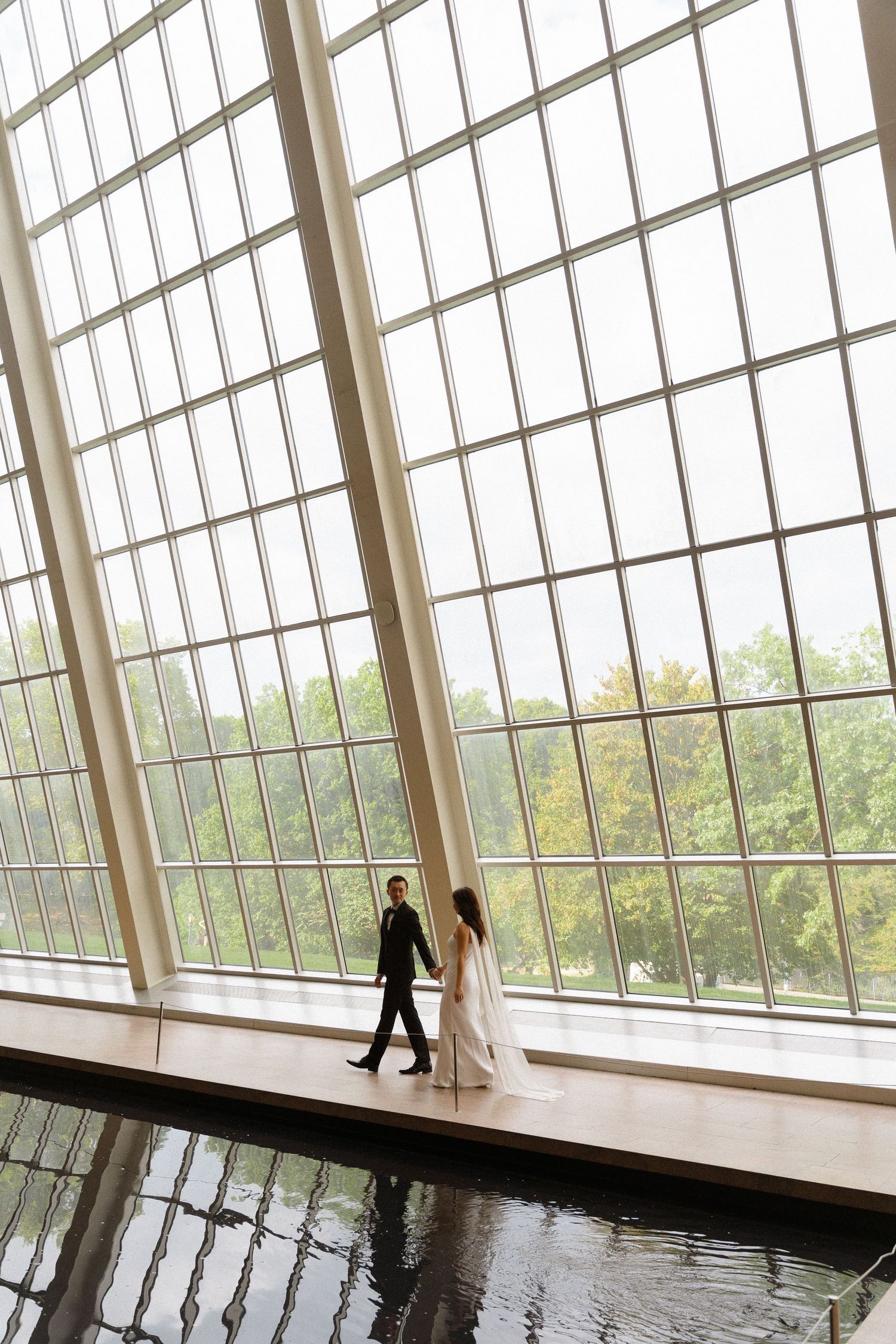 Modern architectural space with angular glass ceiling and reflective floor.