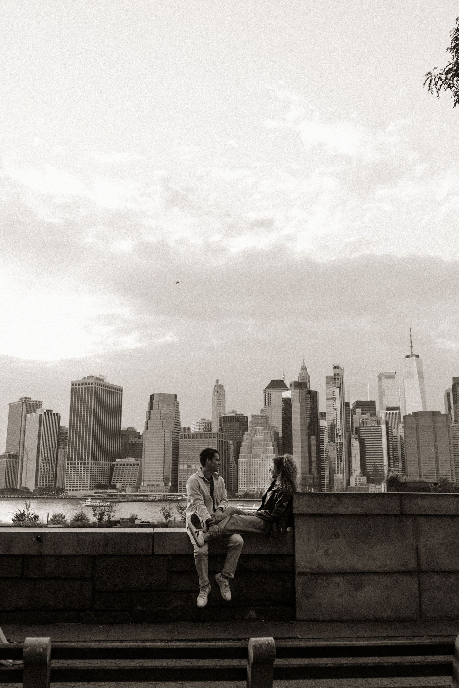 Black and white cityscape photo showing silhouettes against the dramatic New York City skyline.