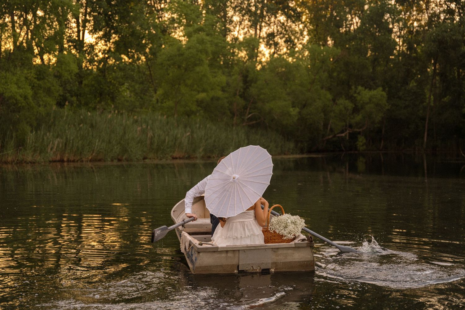 Romantic sunset boat scene with parasol and water reflections.