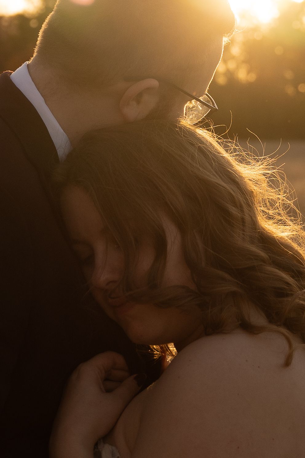 A romantic silhouette against golden sunset light creating a dreamy atmosphere.