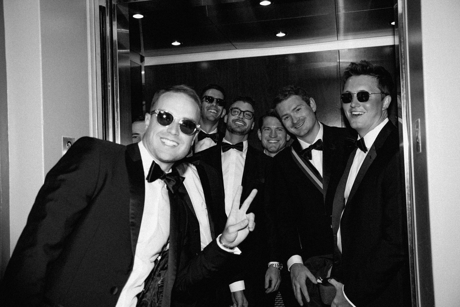 Group of men in formal attire walking through a hallway.