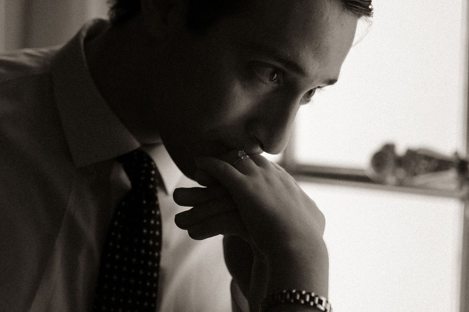 A contemplative profile silhouette against bright window light.