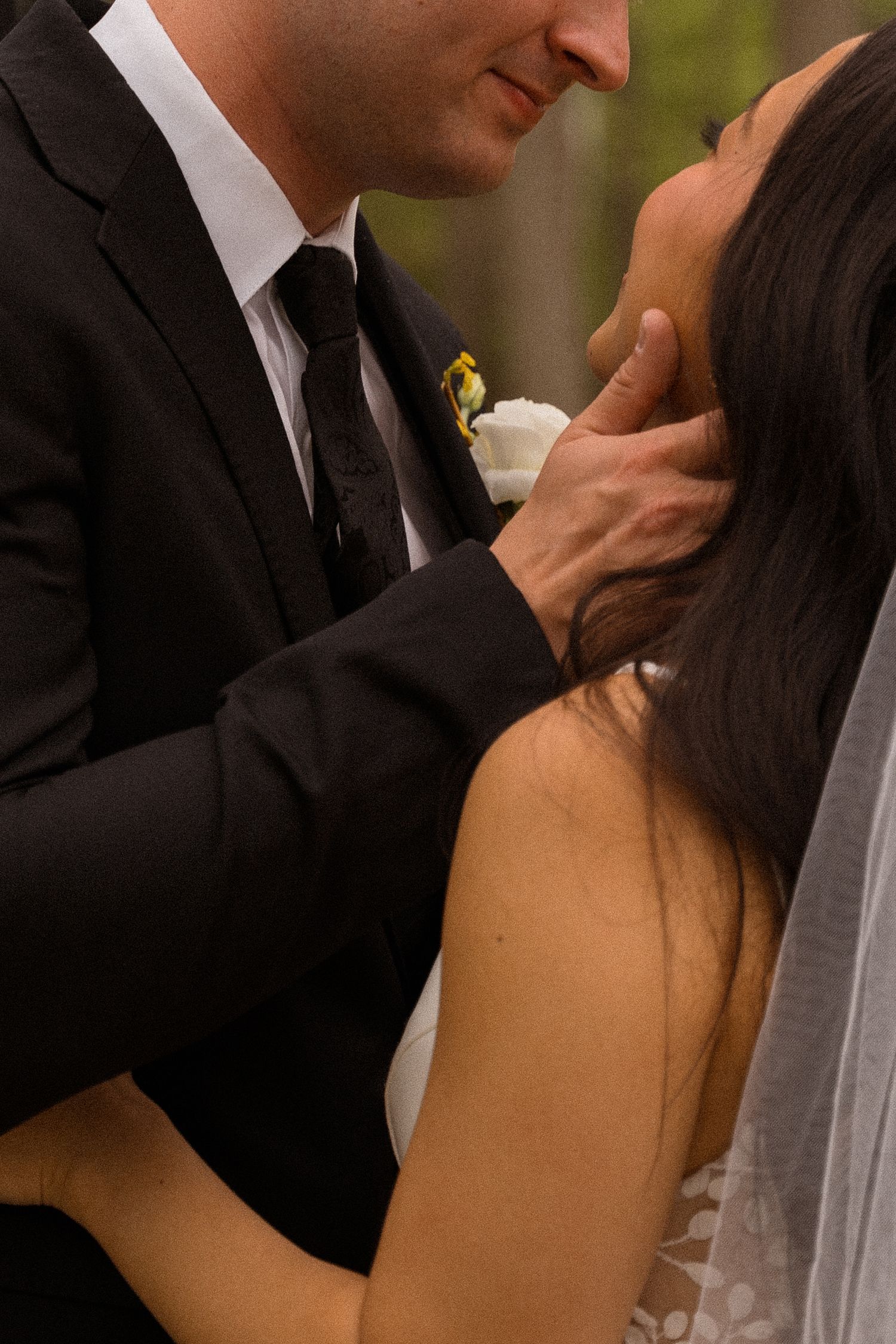 Intimate moment between newlyweds during outdoor wedding ceremony.