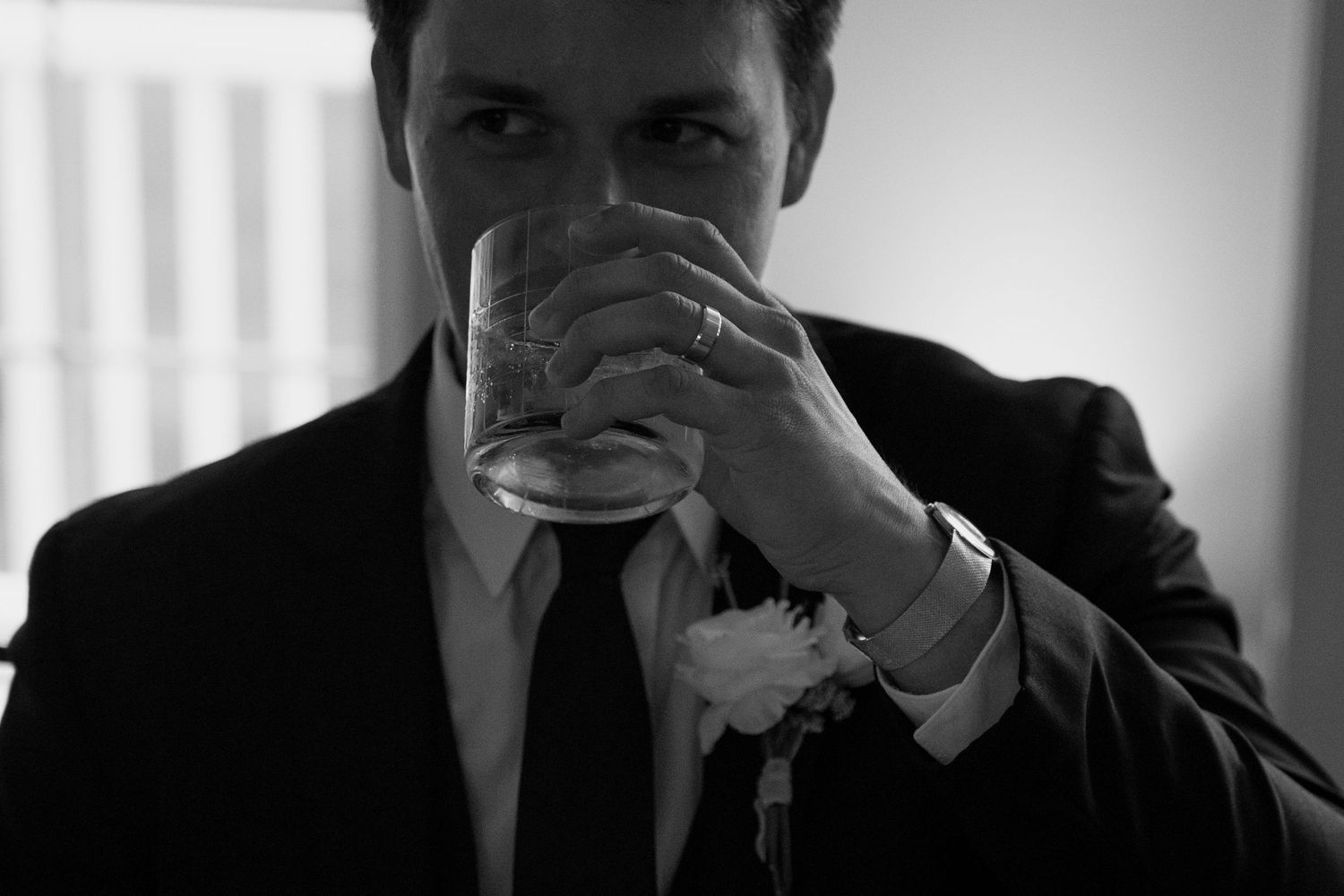 Black and white photo of guests enjoying drinks at a formal event.