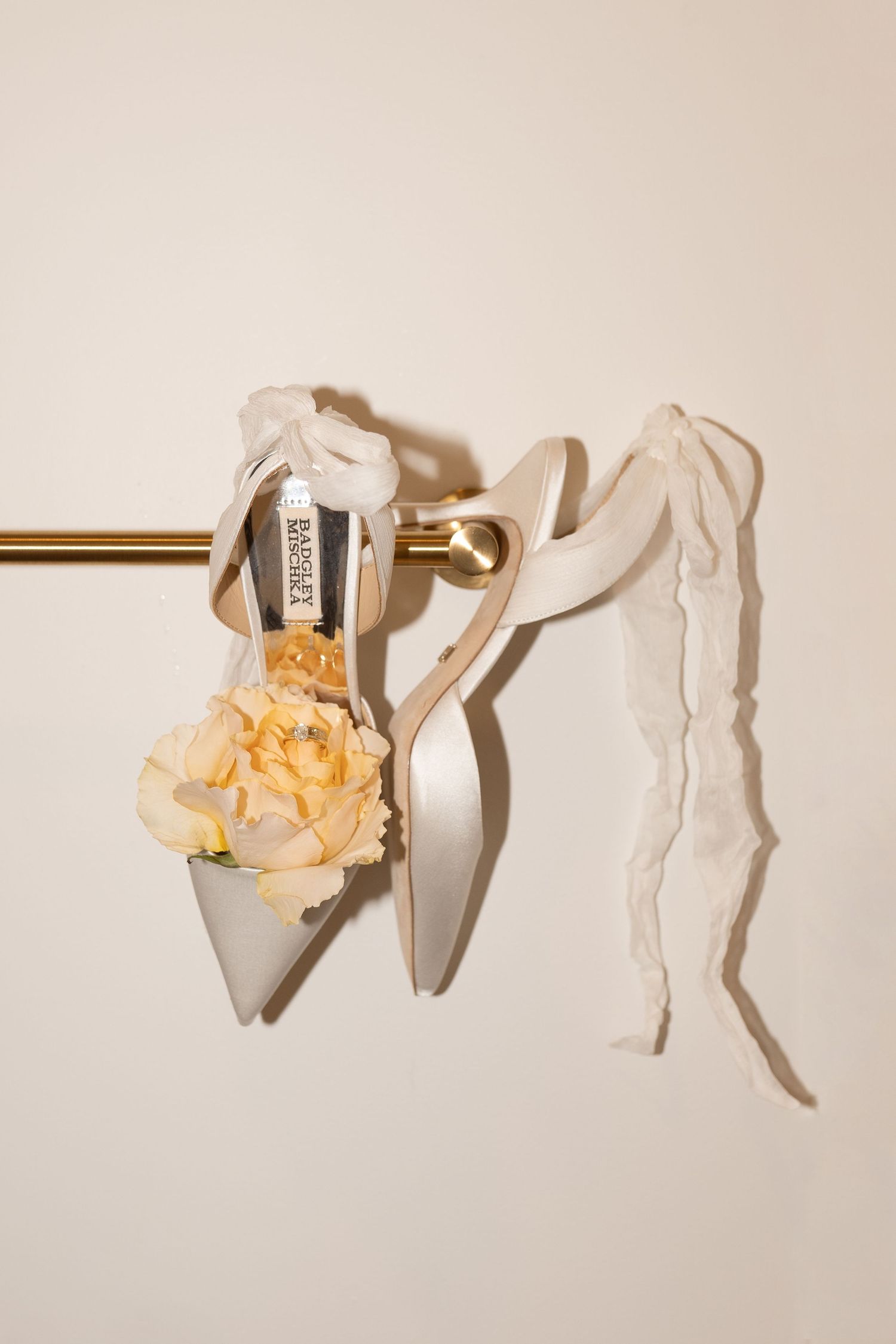 Delicate white ballet slippers with peach-colored roses arranged in an artistic composition.