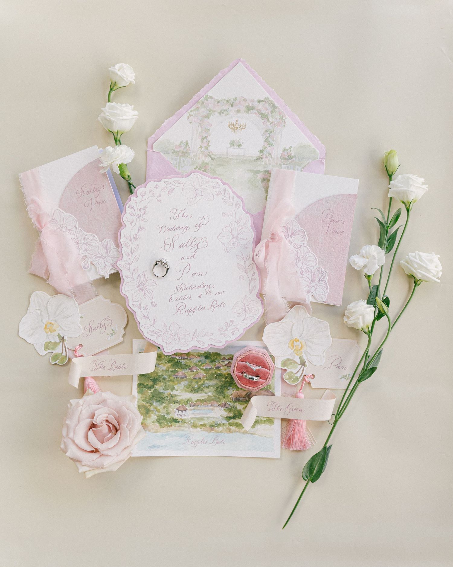 Elegant pink wedding invitation suite with floral details, ribbon, rings, and white roses on a cream background.