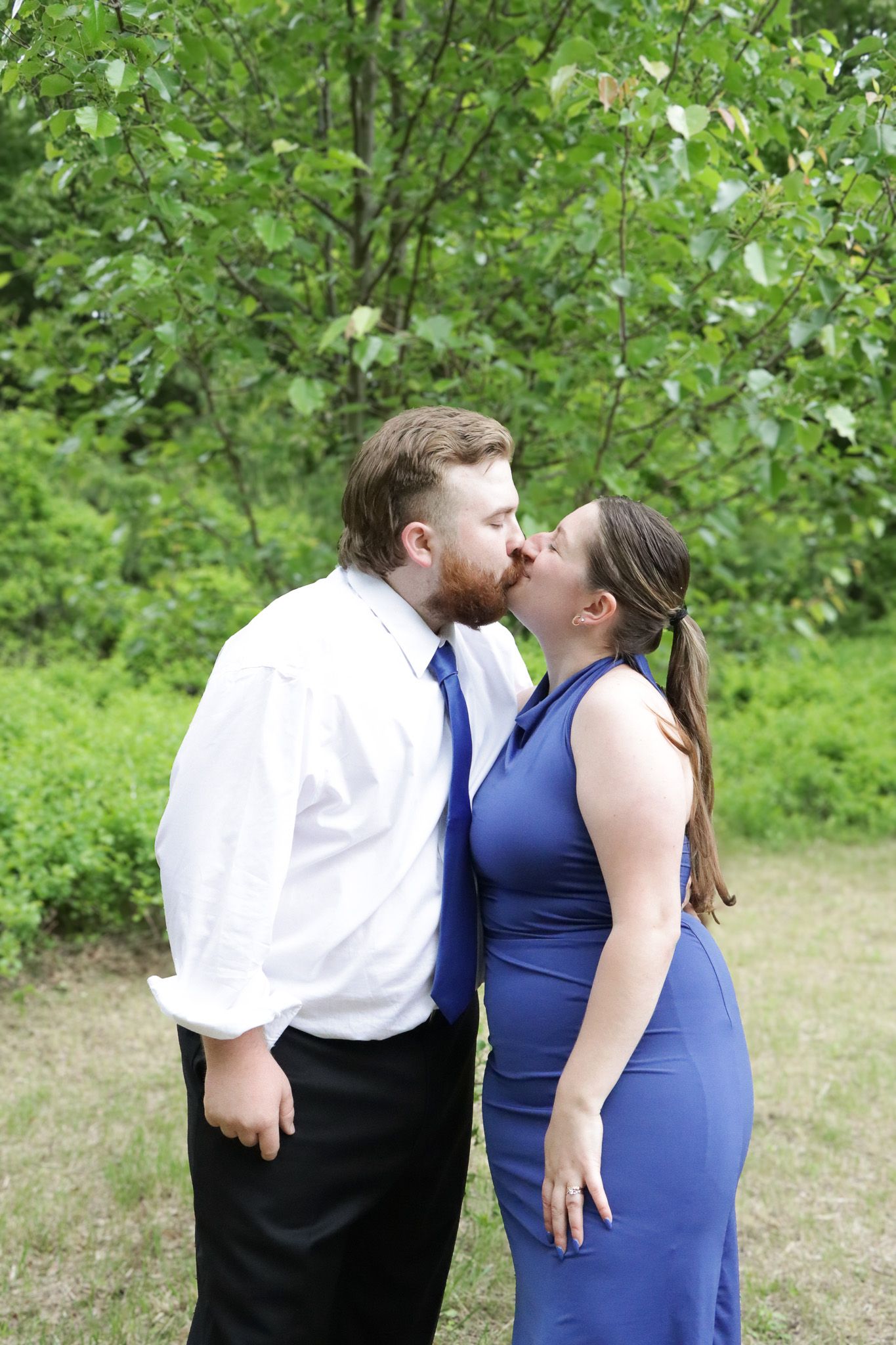 A couple in formal attire share romantic moments in a series of photos taken outdoors against green foliage.