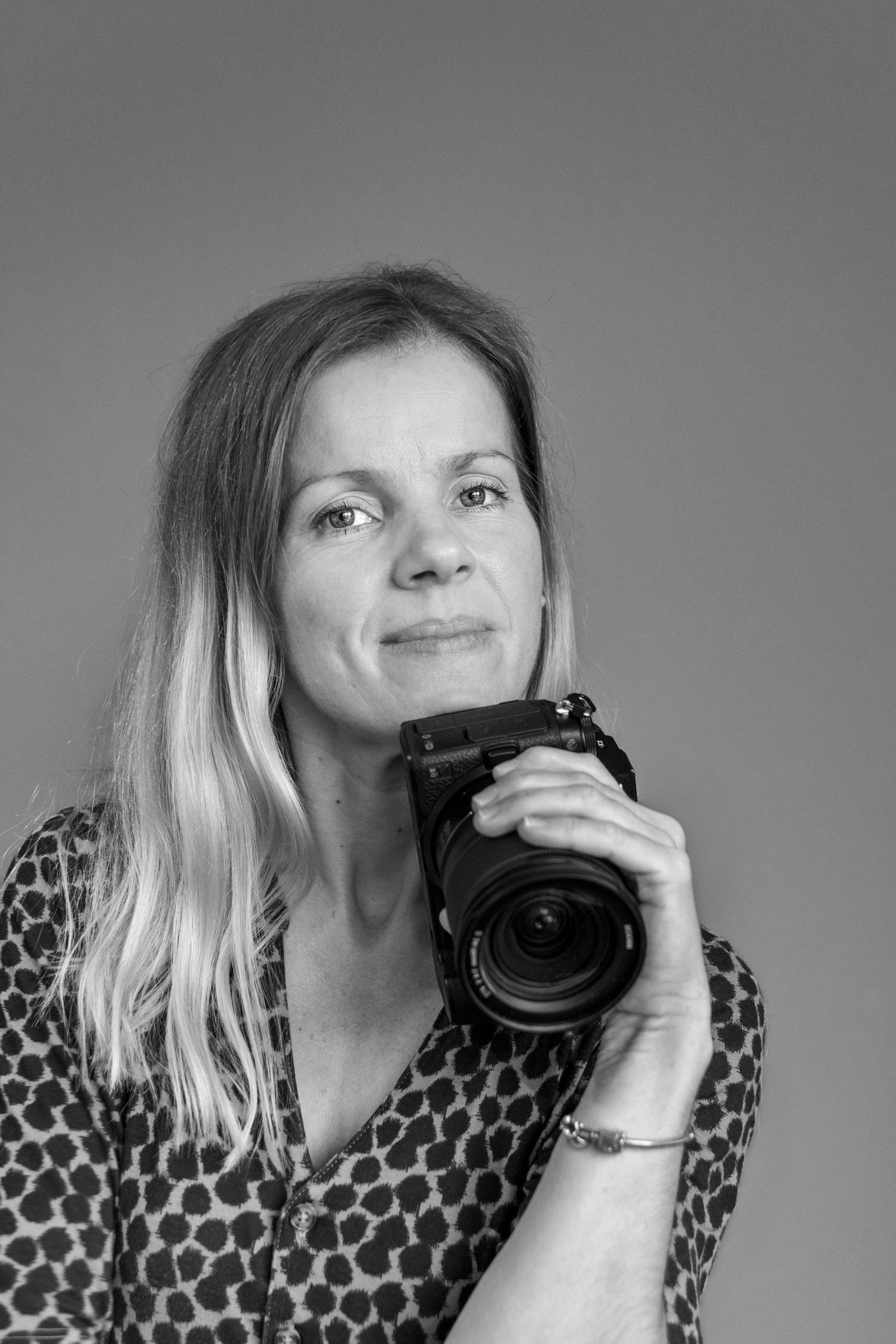 portrait of a women resting her head on the camera she is holding, portrait photography Kent