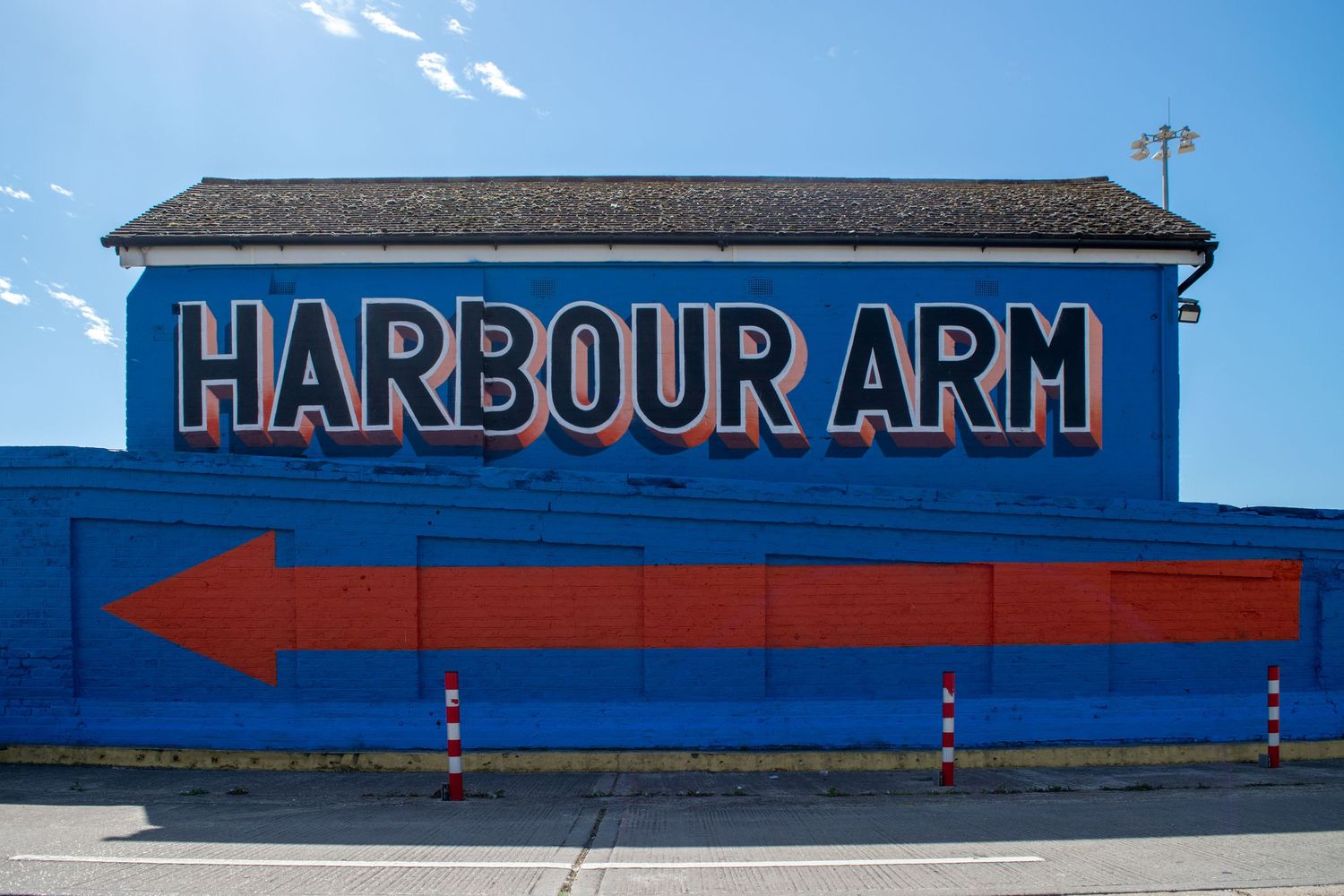 Bright blue building with Harbour Arm graffiti writing, Folkestone pier photography