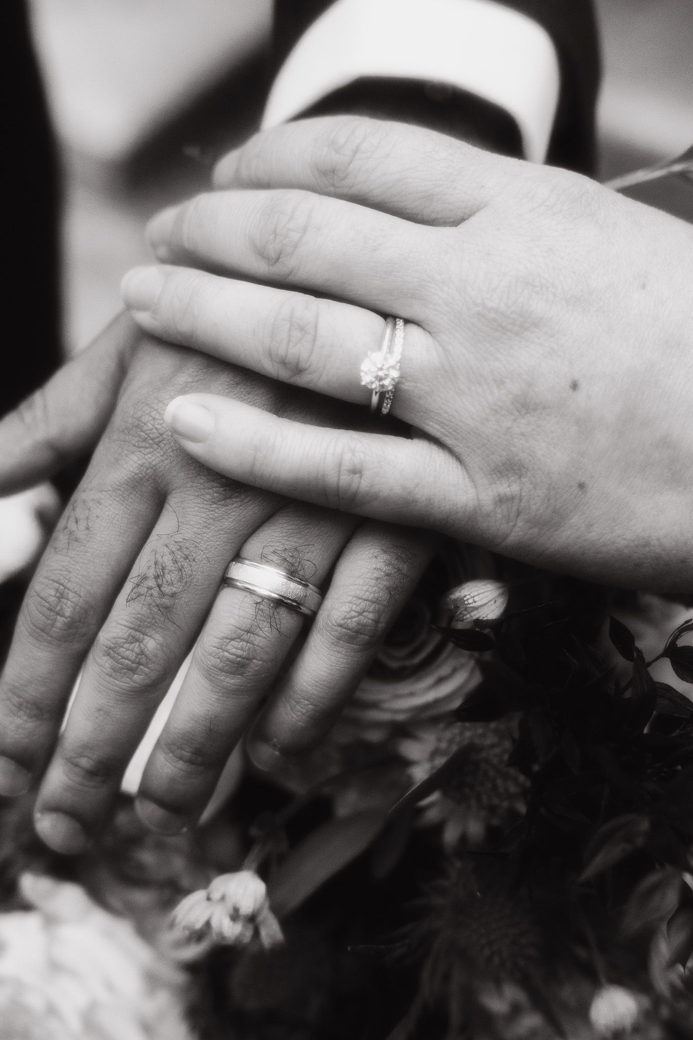 Black and white close-up photo series showing wedding rings on hands from different angles.