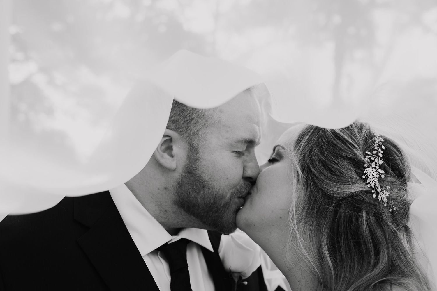Black and white wedding portraits capture tender moments between newlyweds.
