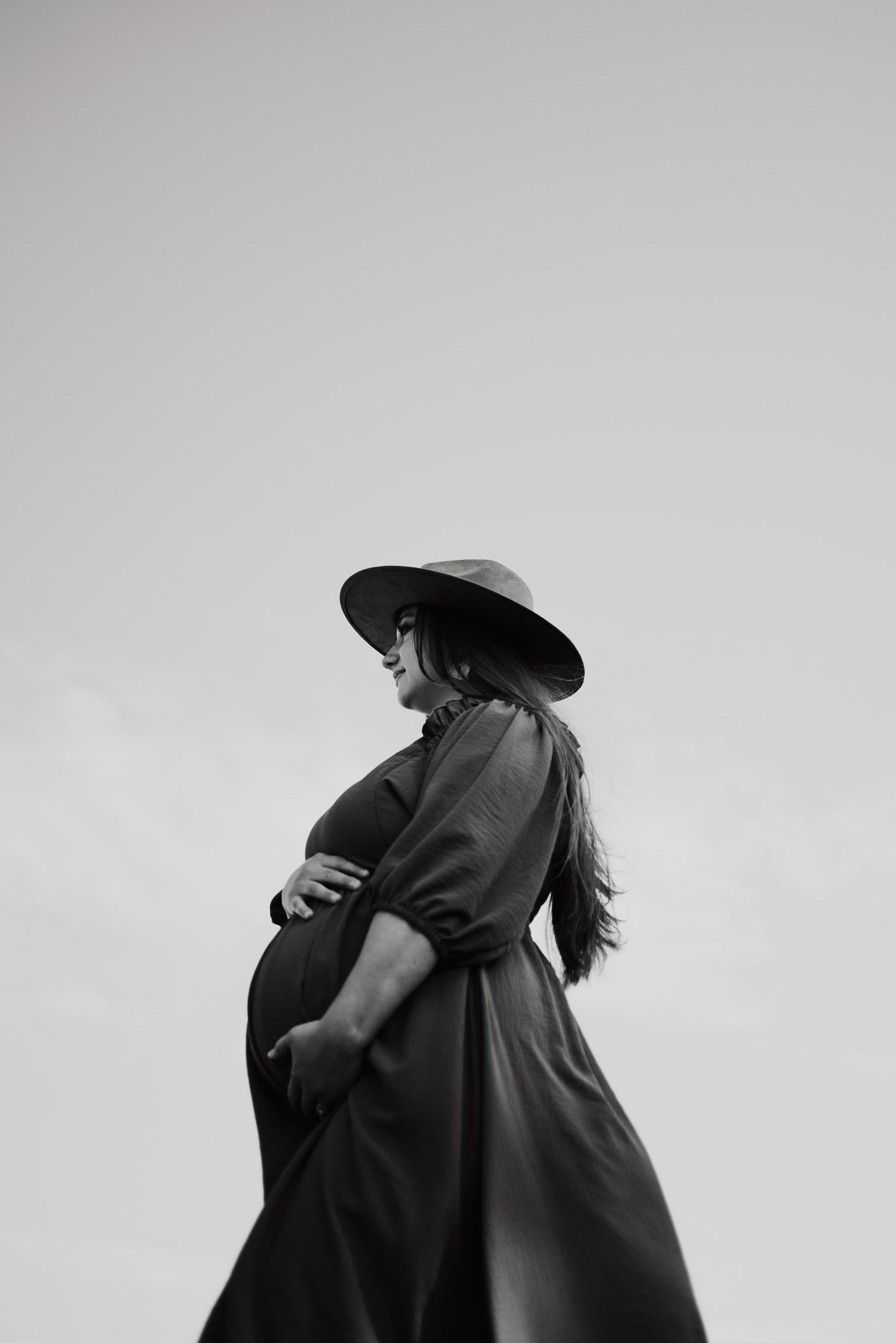 A couple embraces in a tender black and white silhouette against a light background.