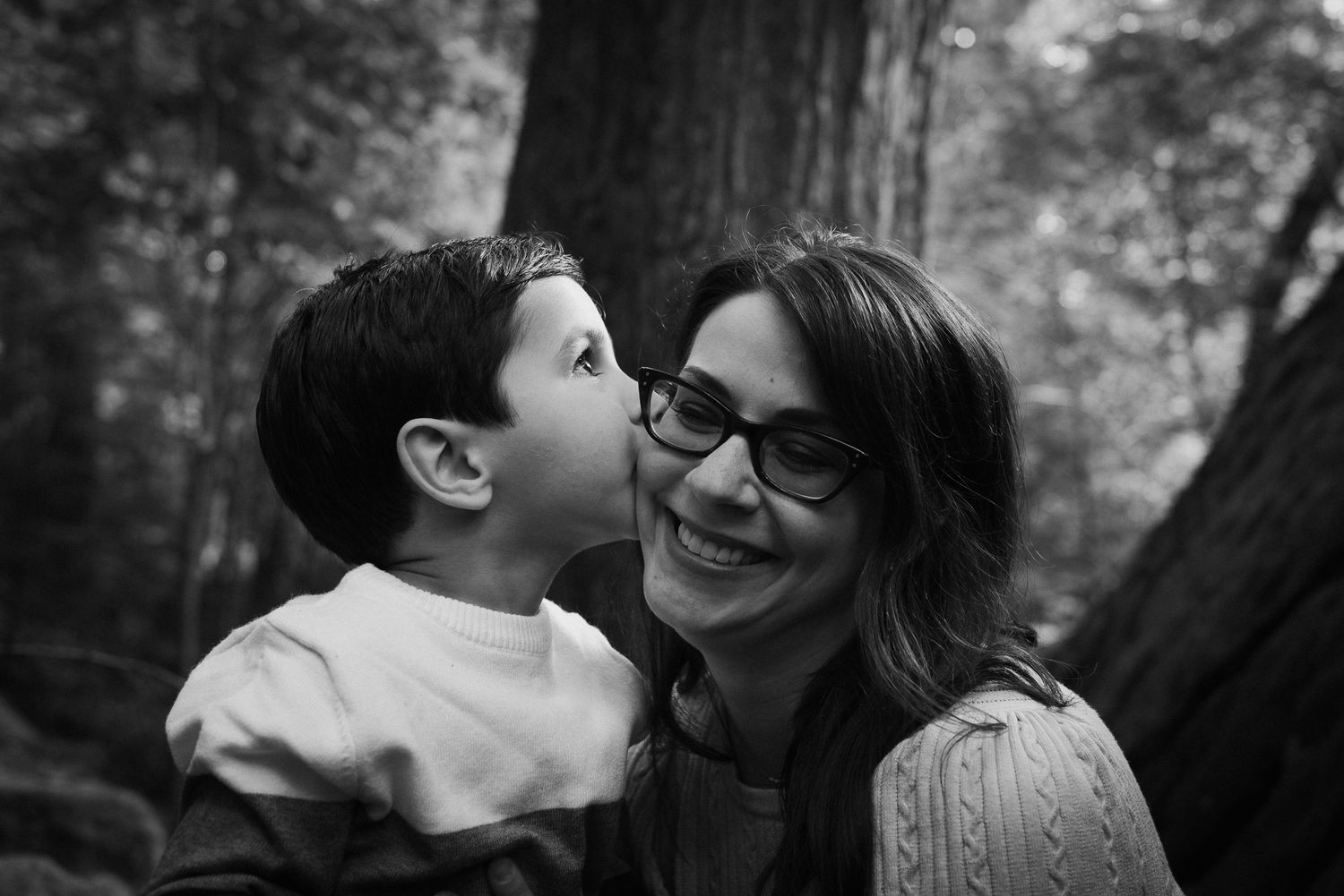 Natural candid moments of affection captured between family members outdoors.